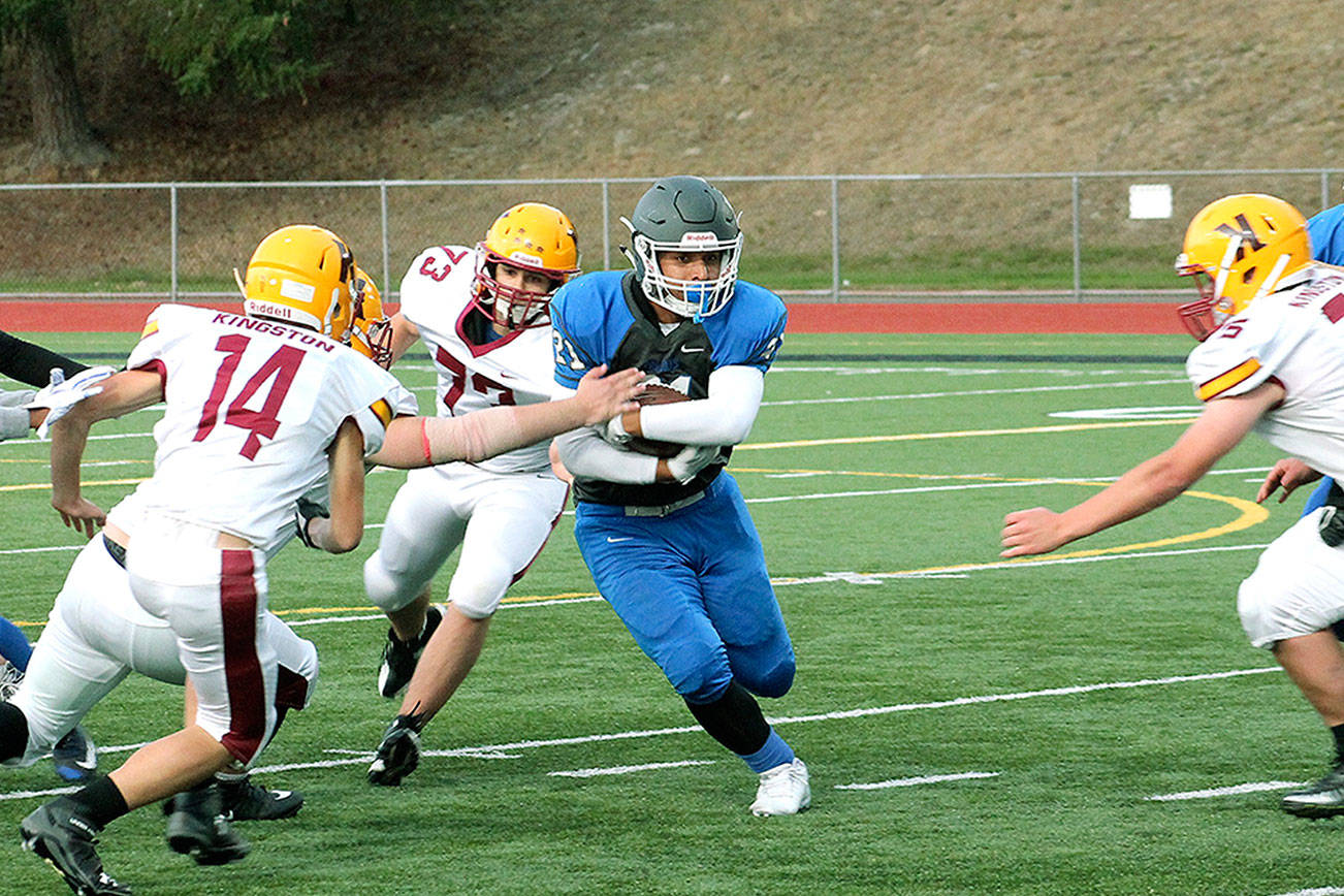 Olympic running back Cameron Bailey slips through the line during the Trojans’ 56-12 win over Kingston. (Mark Krulish/Kitsap News Group)