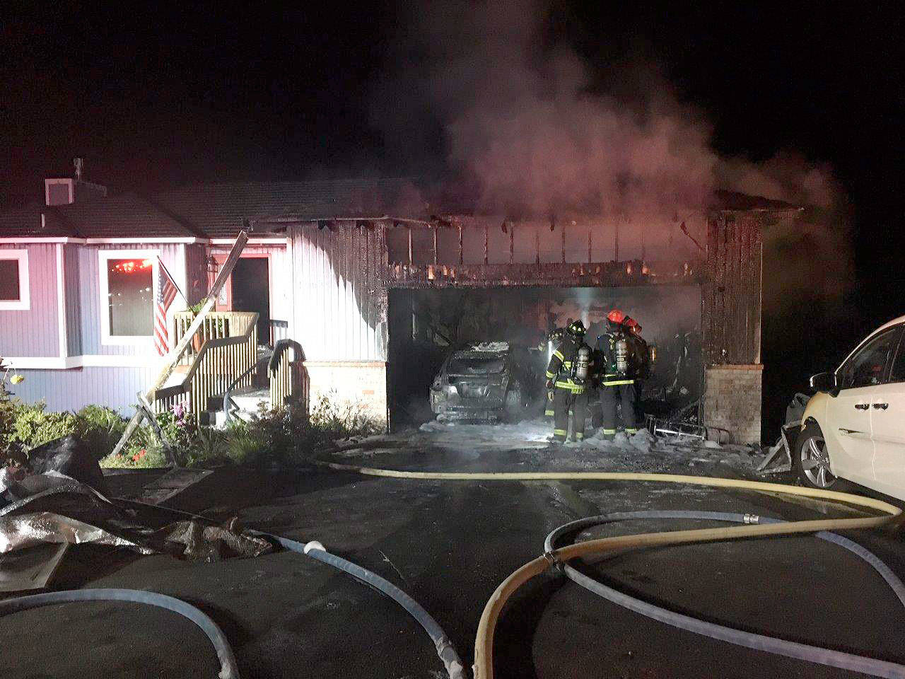 South Kitsap Fire and Rescue crews extinguish a late-night house fire in the Manchester area. (SKFR photo)