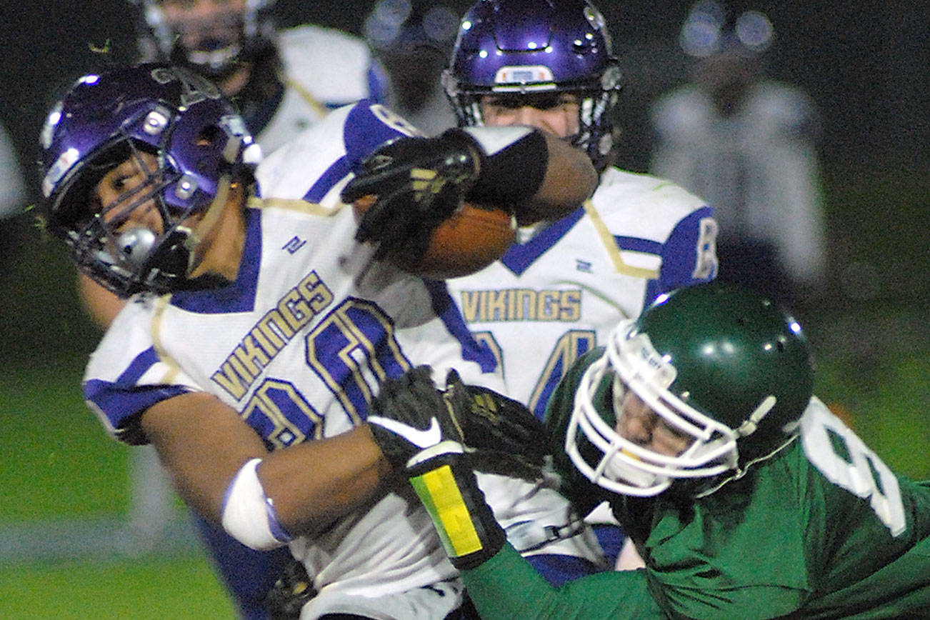 North Kitsap’s Isaiah Kahana fends off the defense of Port Angeles’ Nolan Hughes in the second quarter on Friday at Port Angeles Civic Field. (Keith Thorpe/Peninsula Daily News)