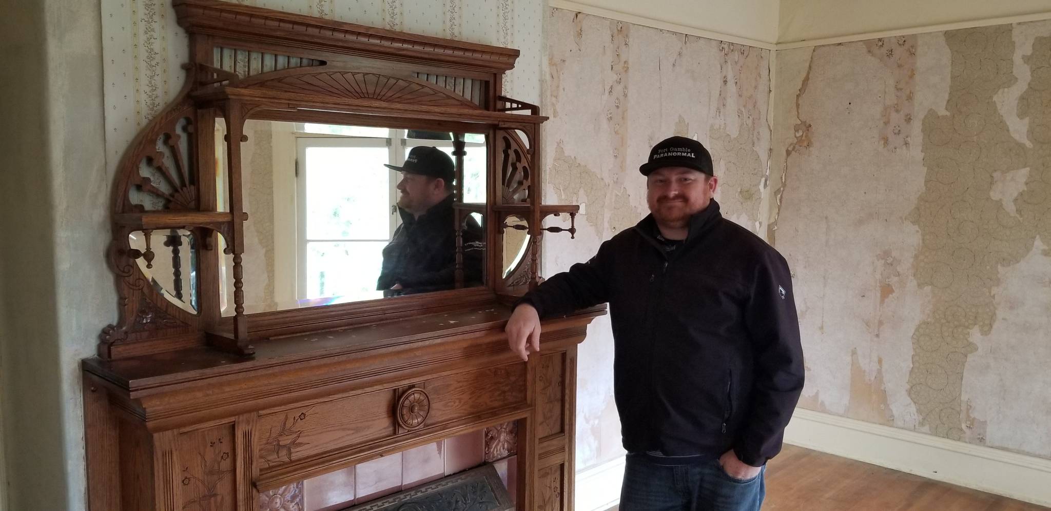 Pete Orbea poses for a photo in front of one of the many fireplaces inside the Walker-Ames House in Port Gamble. Nick Twietmeyer | Kitsap News Group.