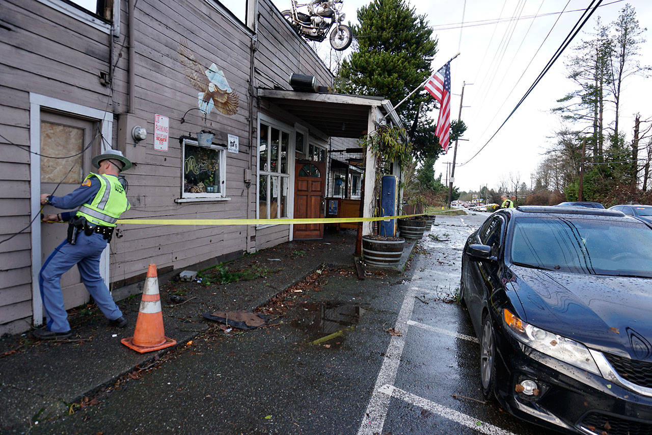 A Washington State Patrol trooper cordons off an area in front of the Bethel Saloon, damaged by a freak tornado that swept through the eastern part of Port Orchard. (Bob Smith | Kitsap Daily News)