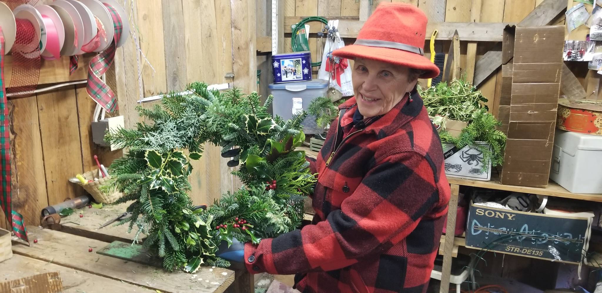 Armstrong shows off one of her handmade “Pacific Northwest” wreaths. Nick Twietmeyer / Kitsap News Group