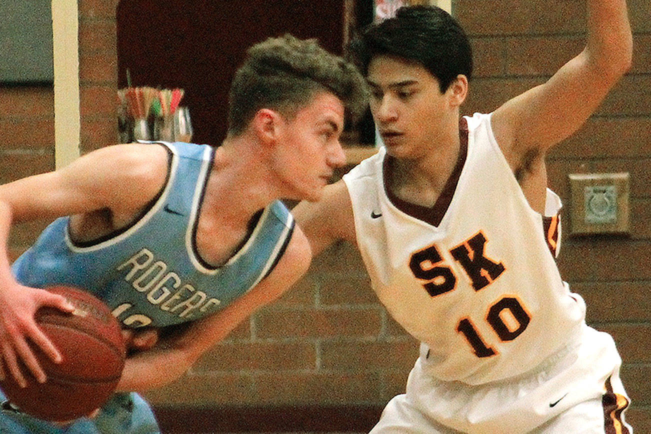 South Kitsap’s Josh Potz (10) closely guards Nick Hansen of Rogers in his team’s 47-37 win. (Mark Krulish/Kitsap News Group)                                South Kitsap senior DeAnte Ward swings the ball across the floor. Ward scored a game-high 18 points against Rogers. (Mark Krulish/Kitsap News Group)