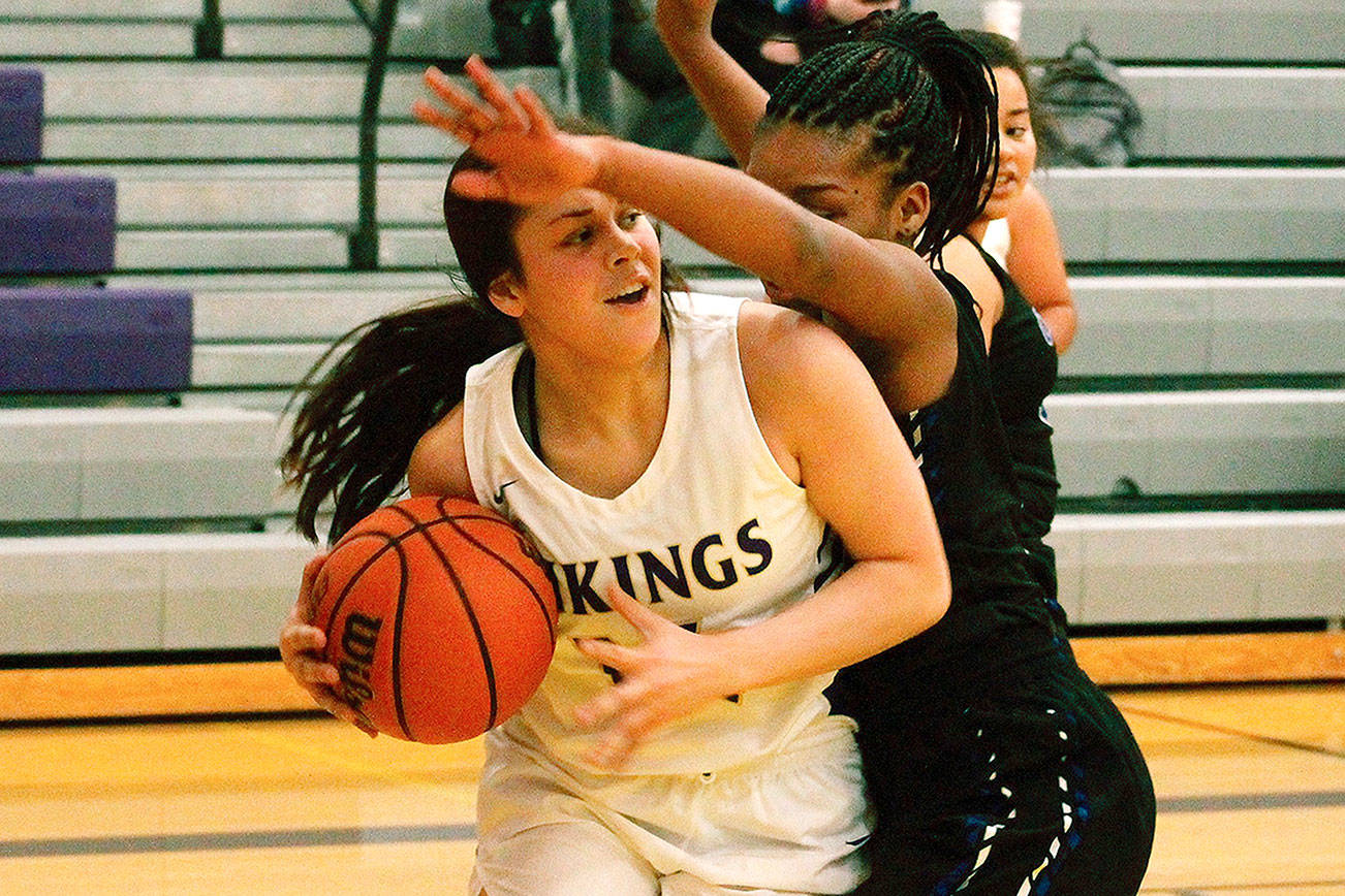 North Kitsap guard Noelani Barreith looks for room underneath the basket while Olympic’s Jakyiiah Willis defends the paint. (Mark Krulish/Kitsap News Group)