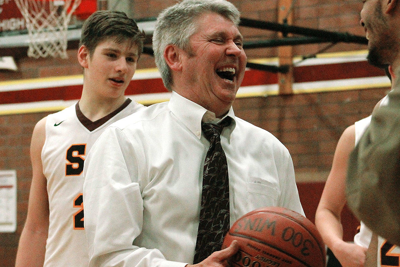 South Kitsap head coach John Callaghan celebrates with the game ball commemorating his 300th career win. (Mark Krulish/Kitsap News Group)