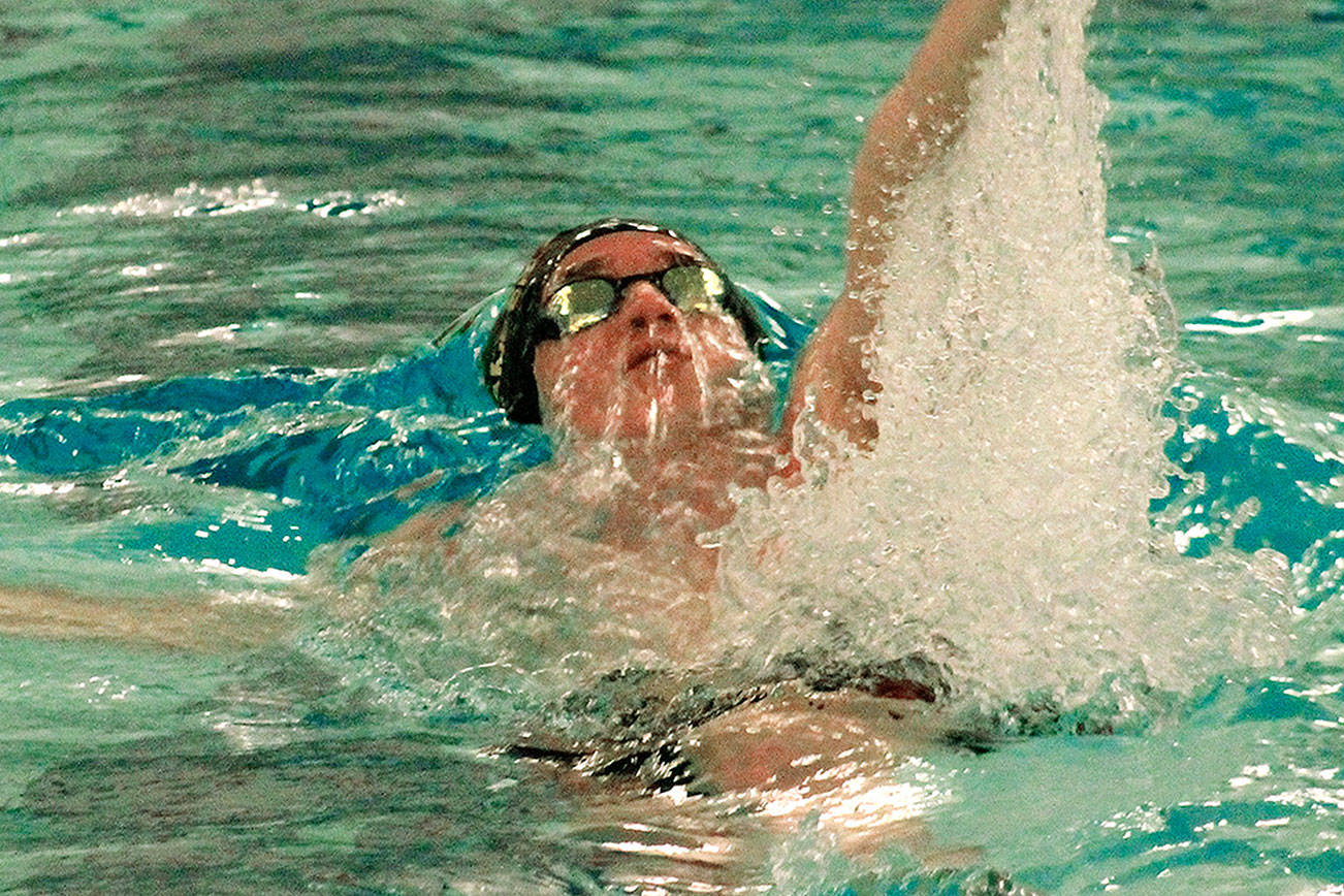 Kingston’s Tim Gallagher swims to victory in the 100-yard backstroke with a time of 52.32. (Mark Krulish/Kitsap News Group)