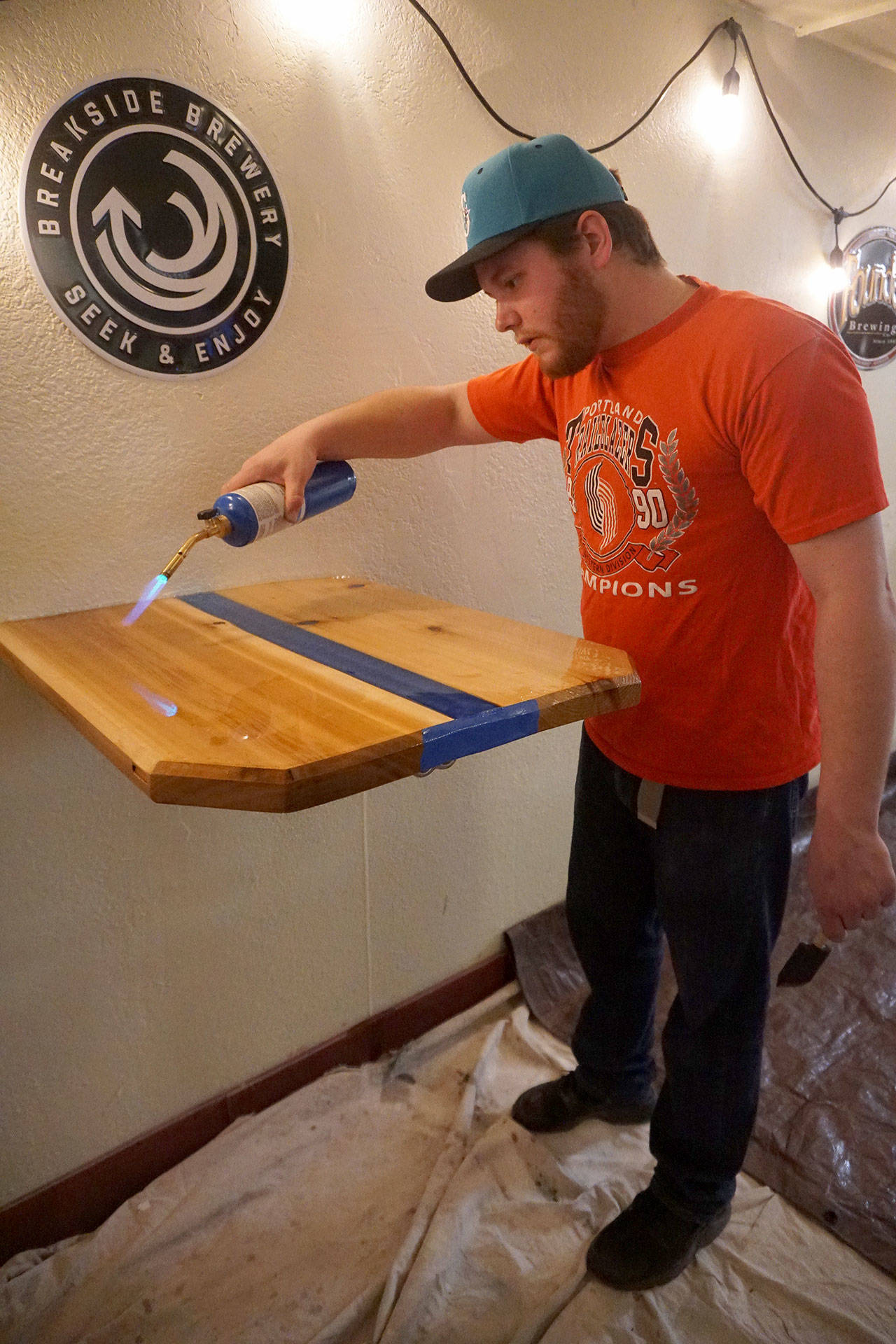 Collective partner Blake Ecklund does some finishing work on one of the customer tables. (Bob Smith | Kitsap Daily News)