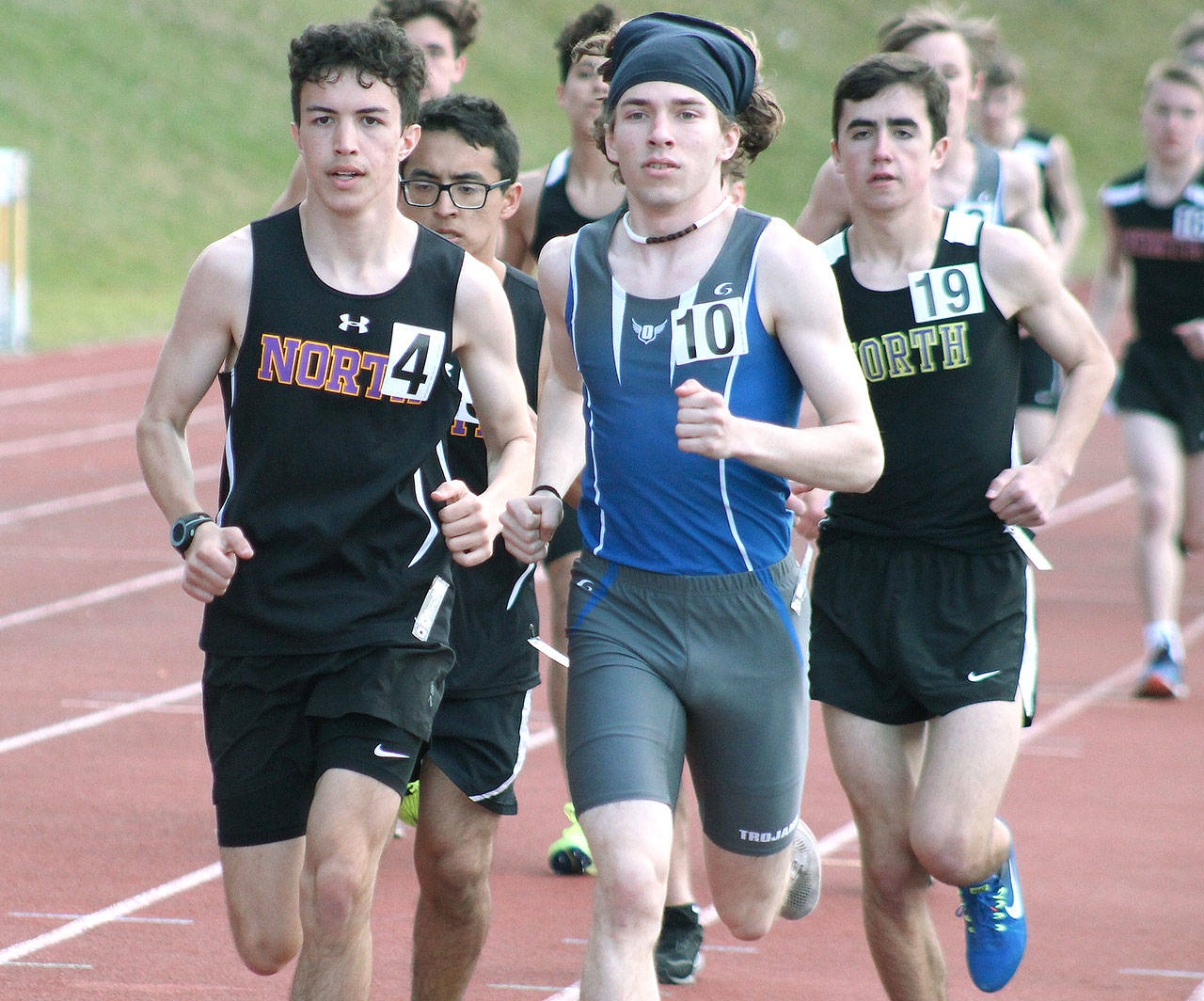 Olympic’s Scott Ashcraft (10) runs neck-and-neck with North Kitsap’s Max Metters in the 1600-meter run. (Mark Krulish/Kitsap News Group)