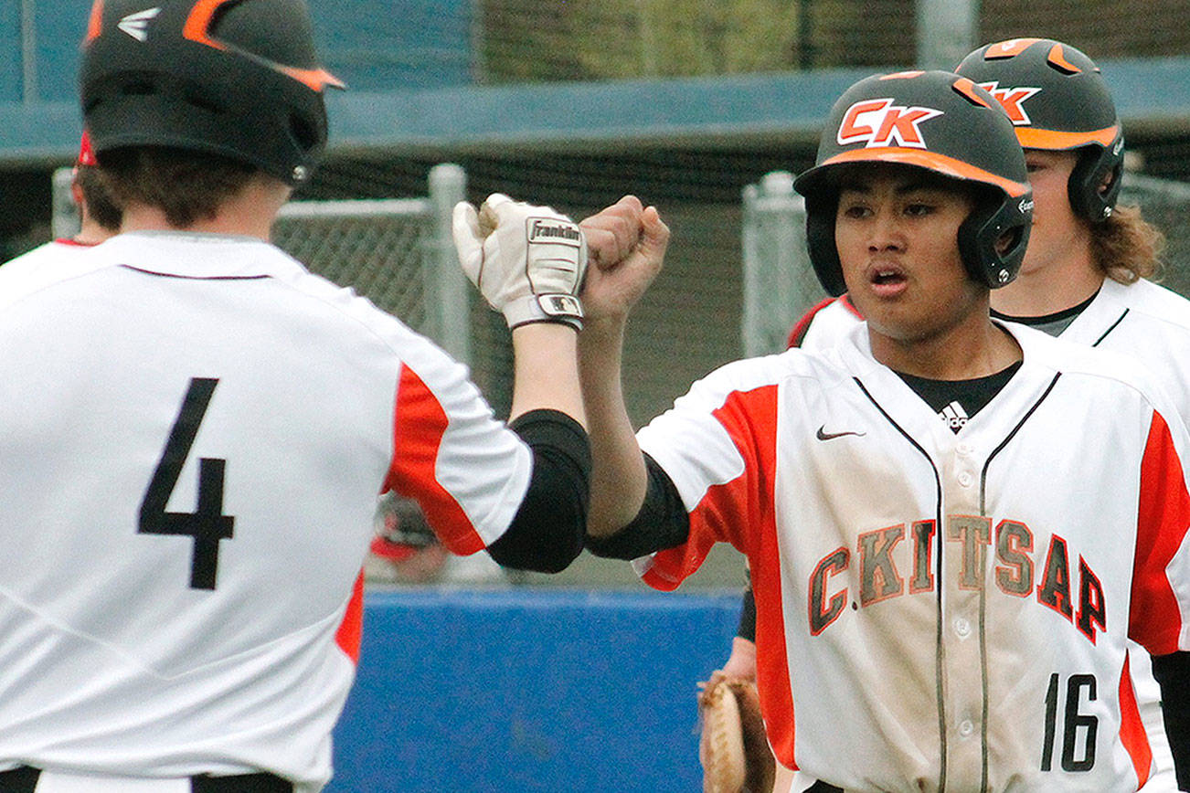 Jaiden Tolentino-Balagtas fist-bumps with Austin McMinds (4) after scoring the final run of the game against Shelton. (Mark Krulish/Kitsap News Group)