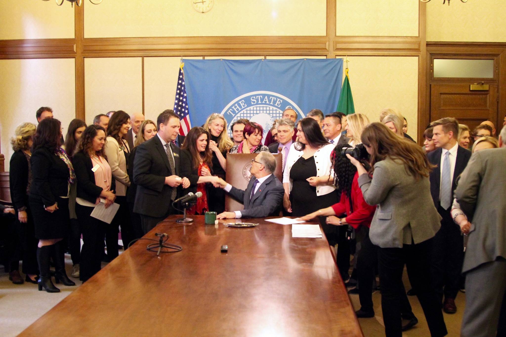 Gov. Jay Inslee shakes hands with Dinah Griffey after signing Senate Bill 5649. Inslee mentioned both Rep. Dan Griffey and his wife Dinah Griffey in his remarks on the bill. Photo by Emma Epperly, <em>WNPA Olympia News Bureau</em>