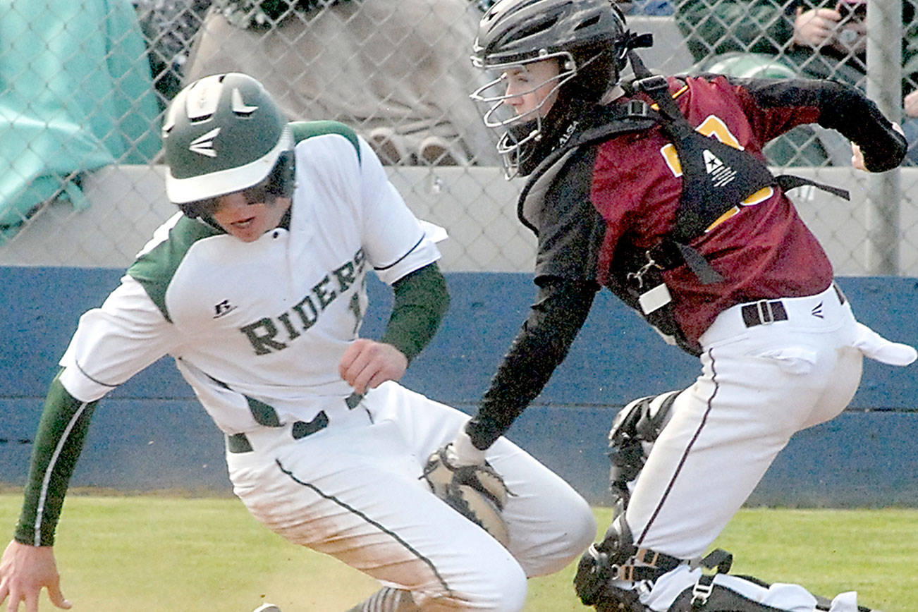 Port Angeles Ethan Flodstrom, left, attempts to steal home as Kingston catcher Tyler Bates, cuts him off for an out during the third inning on Wednesday at Port Angeles Civic Field. (Keith Thorpe/Peninsula Daily News)