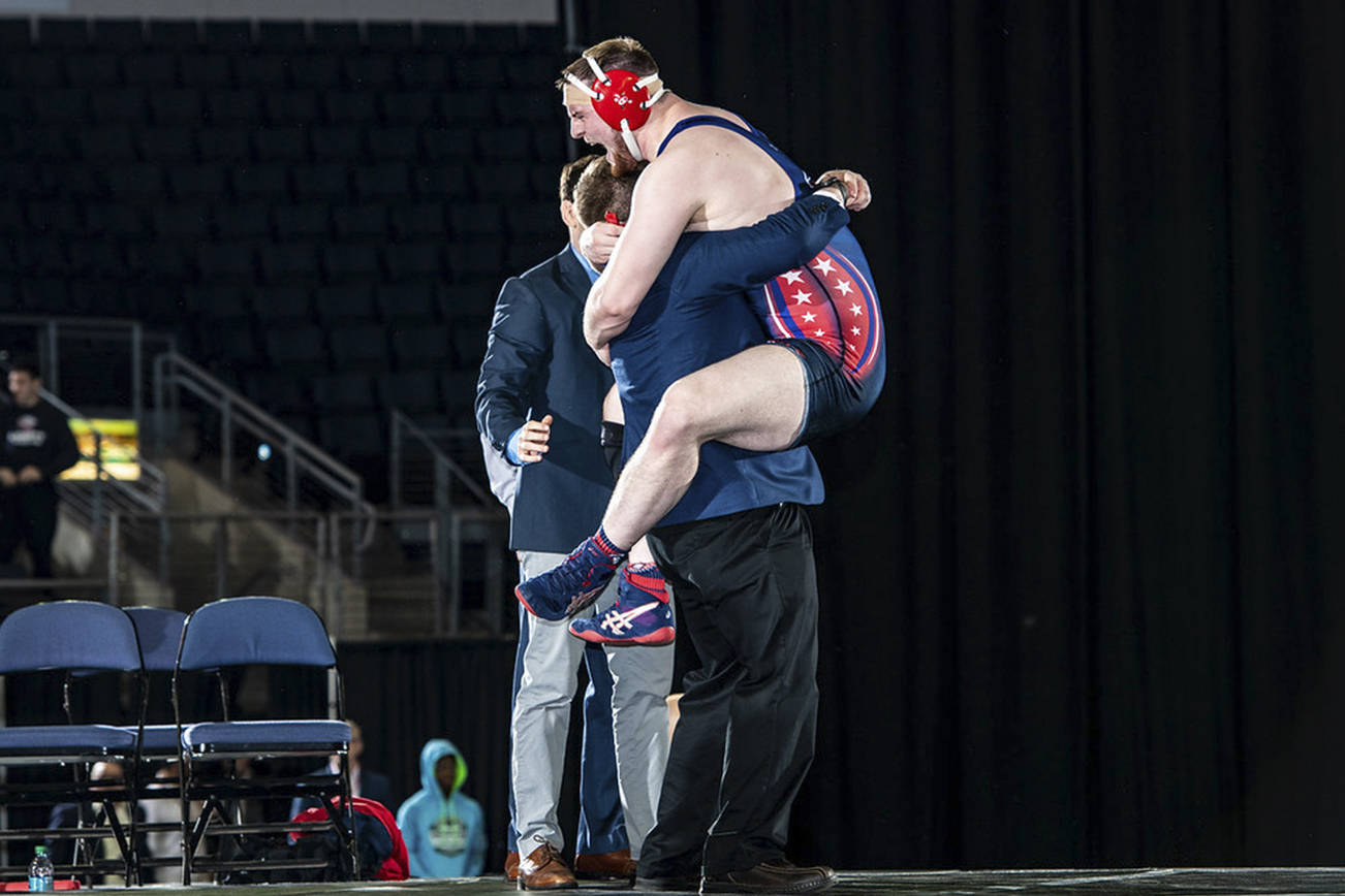 <em>Johnson leaps into the arms of his coach after winning a national championship.</em>                                Sam Janicki/contributed