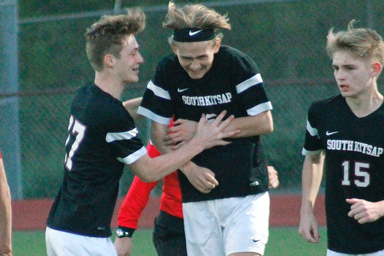 Blake Mason gets congratulated by teammates Dylan Ruth and Brian Yand after scoring in the 62nd minute of the match against Bellarmine Prep. It was the only goal of the game in the South Kitsap victory. (Mark Krulish/Kitsap News Group)