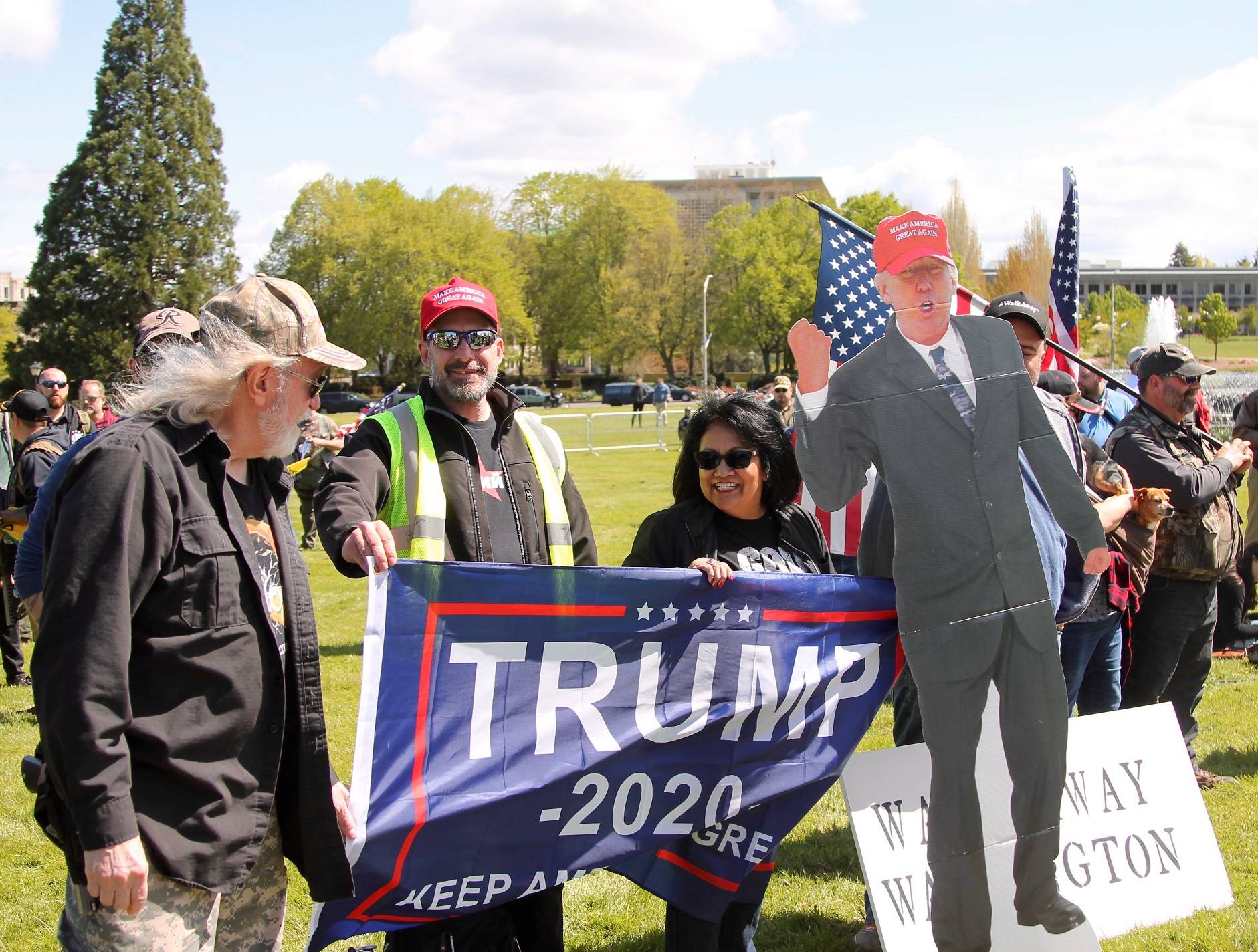 Attendees at the “March for Our Rights” gun rally hold a President Donald Trump cardboard cutout and Trump 2020 Flag. — Photo by Emma Epperly, WNPA Olympia News Bureau