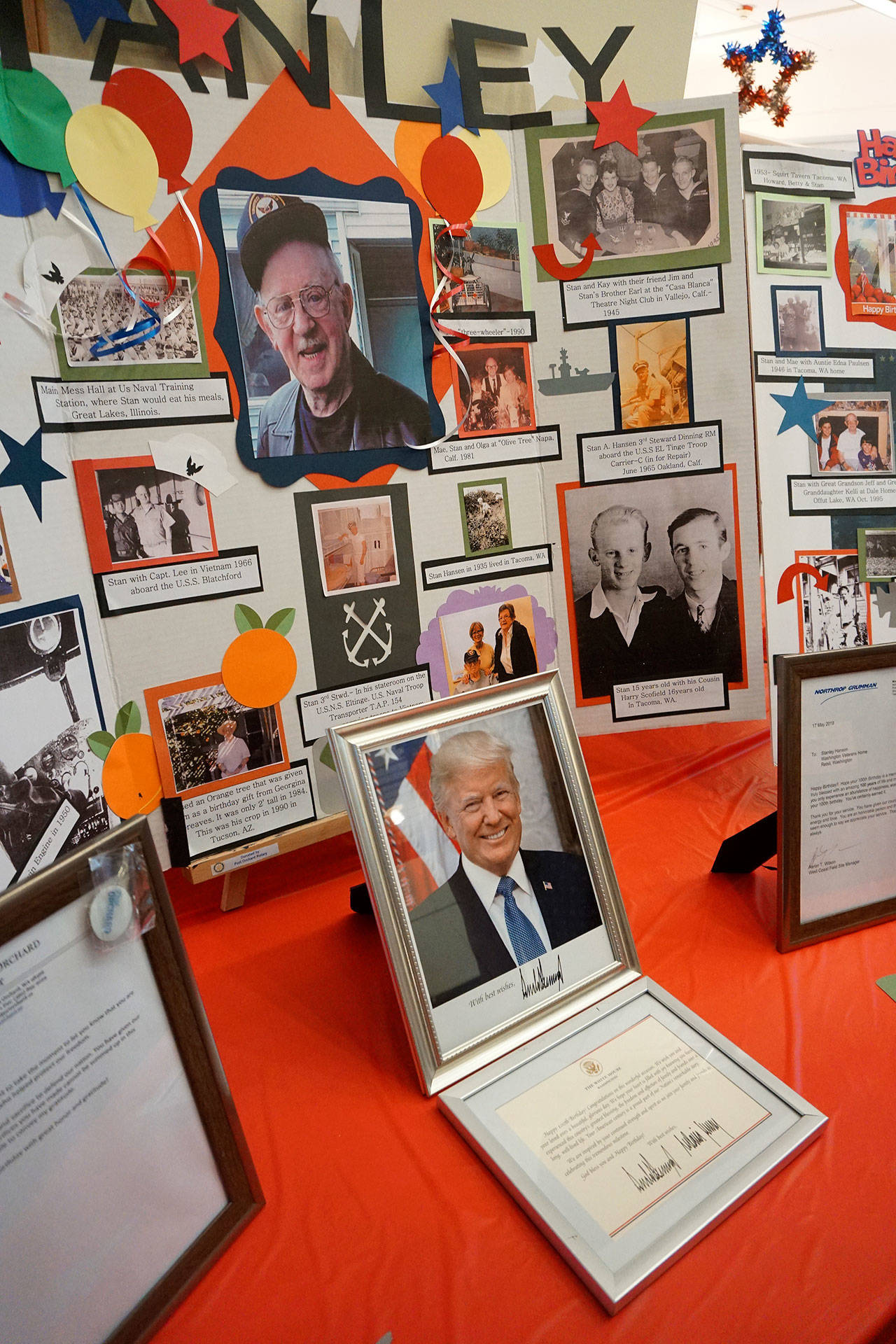 A collection of photographic memories, including congratulatory letters from President Trump and Gov. Inslee, are displayed at Stanley Hansen’s 100th birthday celebration. (Bob Smith | Kitsap Daily News)