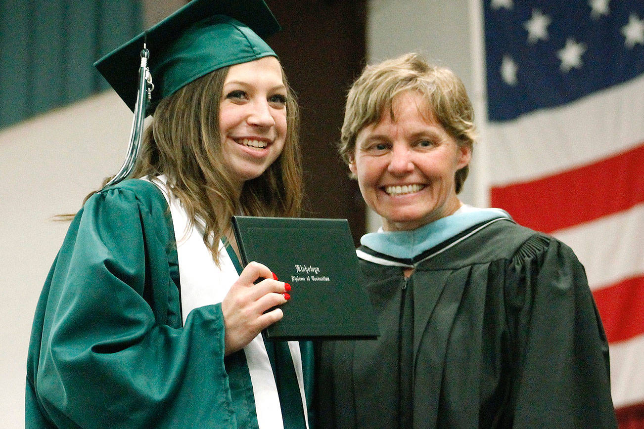 Kylie Woodrum (left) holds up her diploma with Klahowya principal Jodie Woolf. (Mark Krulish/Kitsap News Group)