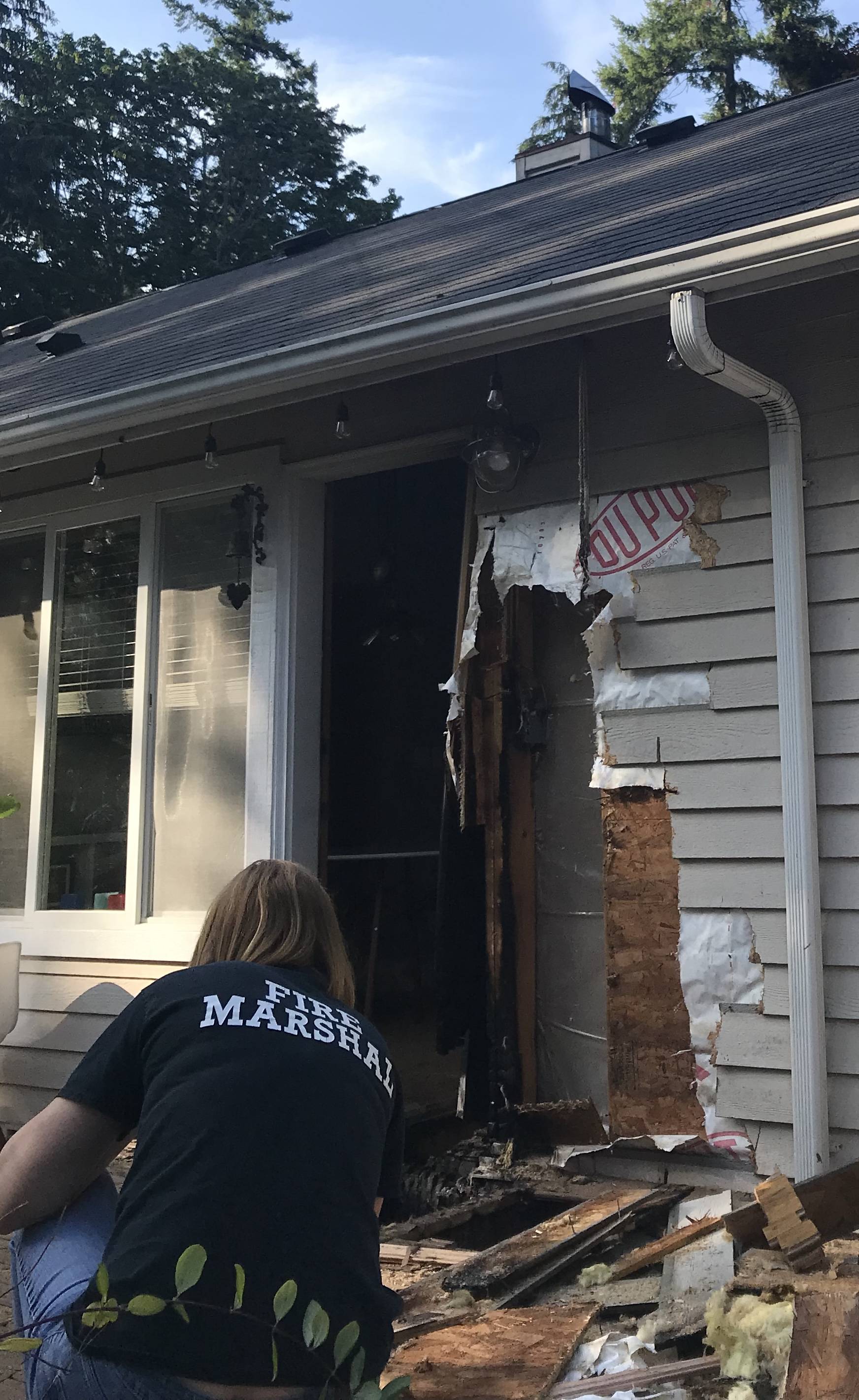 Deputy Fire Marshal Kristi Wlodarchak examines the debris from a fire, stopped before it caused more damage due to a combination of technology and fast firefighter response, at a Kingston-area home Sunday evening. Photo courtesy Poulsbo Fire Department