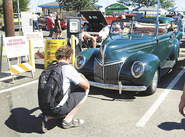 A CRUZ Car Show fan in 2016 checks out a classic vehicle on display. (Bob Smith | Kitsap Daily News 2016)