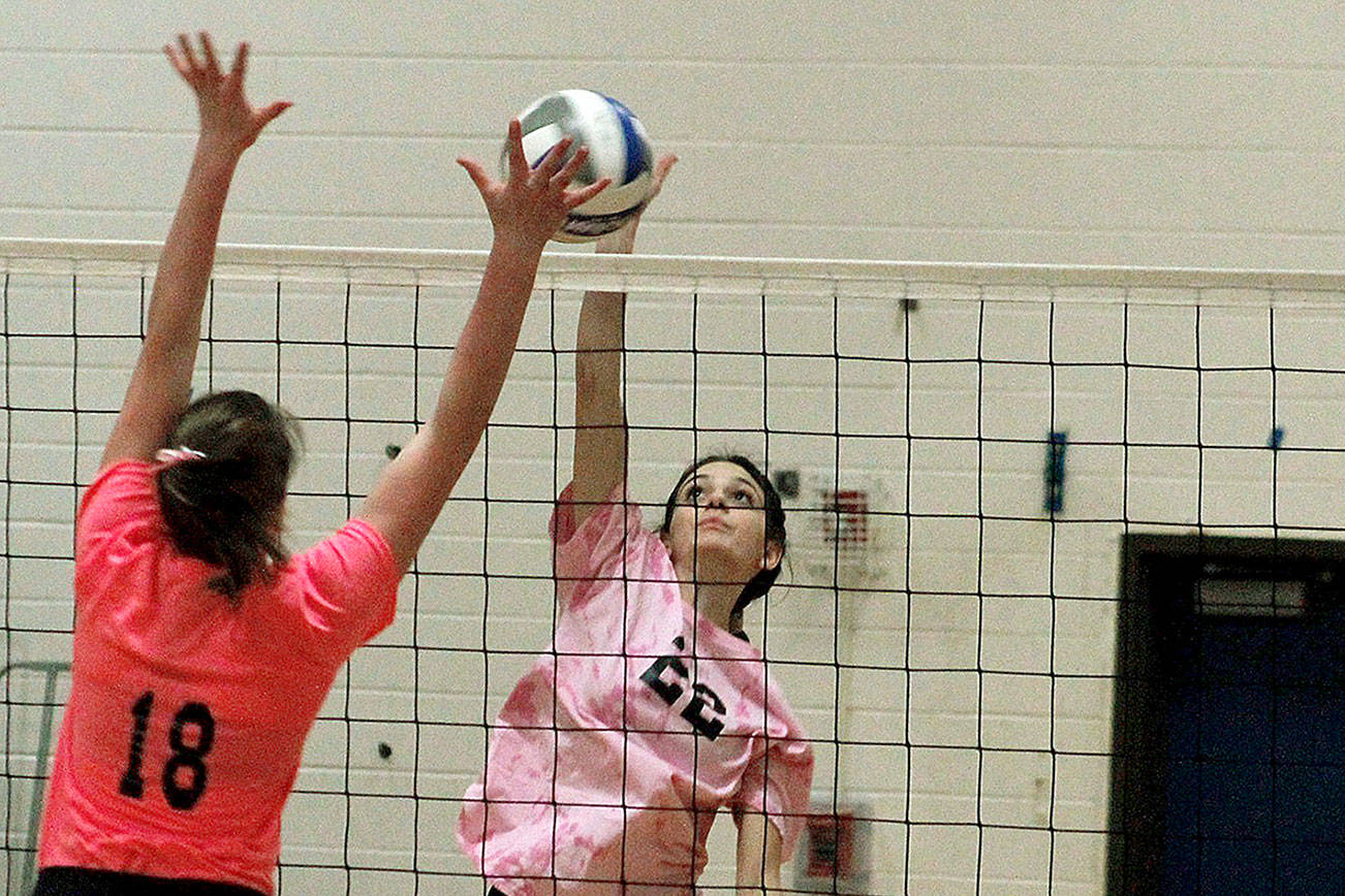 Klahowya junior Anna Bell fights for a ball at the net with Olympic’s Faith Harer (18) in their match on Thursday night. (Mark Krulish/Kitsap News Group)