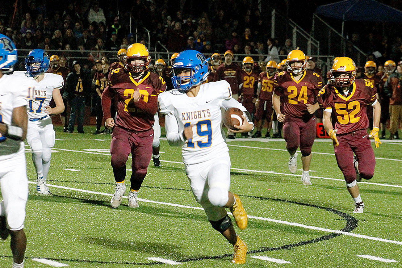 Sophomore quarterback Joshua Tapangco rushes around the edge against Kingston. (Mark Krulish/Kitsap News Group)