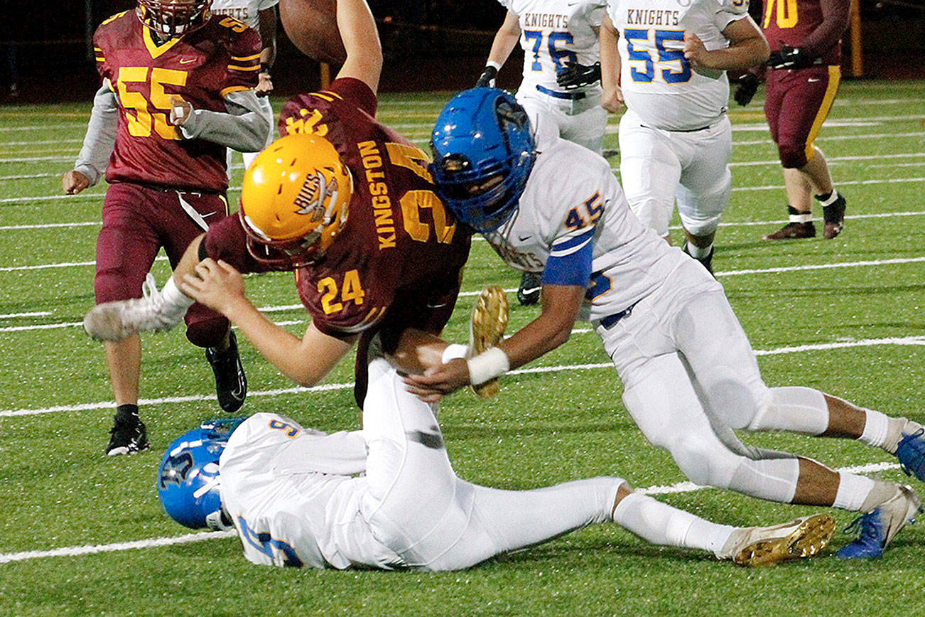 Bremerton’s Keith Jackmon (9) and Kaipo Retome (45) collide with Kingston’s Garrett Sitting-Dog (24) in the first quarter of the Knights’ 30-20 victory. (Mark Krulish/Kitsap News Group)