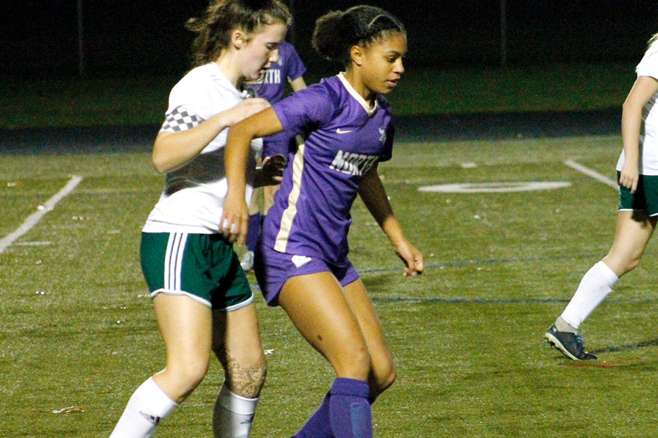 Kamora McMillian keeps her defender at bay as she makes a pass to her teammate against Port Angeles. (Mark Krulish/Kitsap News Group)