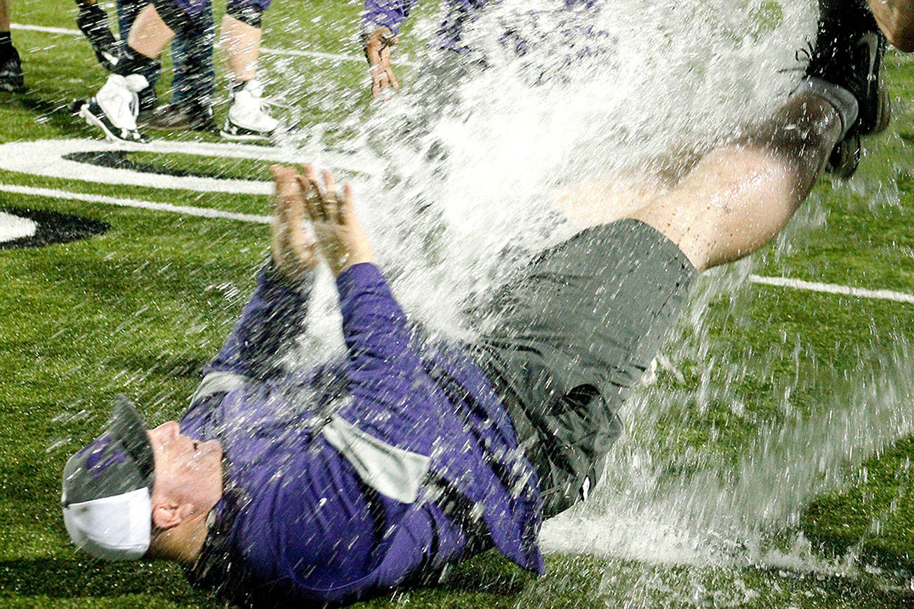North Kitsap head coach Jeff Weible unsuccessfully tries to get away from an impending Gatorade shower after his team clinched the Olympic League championship. (Mark Krulish/Kitsap News Group)