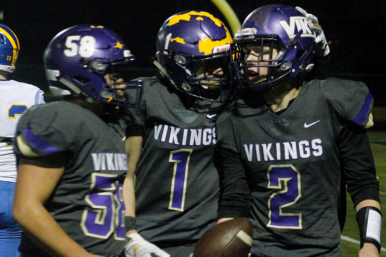 Manny Oliveros (58) and Aidan King (1) celebrate with North Kitsap quarterback Colton Bower after his third touchdown tied their playoff game against Fife in the fourth quarter. (Mark Krulish/Kitsap News Group)
