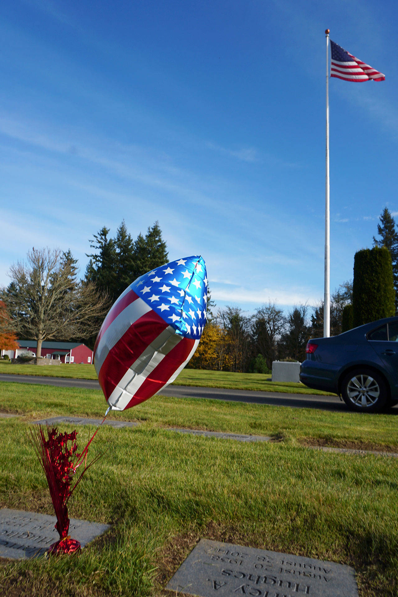Cemeteries containing the remains of honored veterans — including Sunset Lane Memorial Park in Port Orchard — were visited by somber family members on this quiet Monday afternoon who left miniature flags and small stars-and-stripes-adorned balloons next to the plaques and monuments of their loved ones who served the nation at some point of their lives. (Bob Smith | Kitsap Daily News)