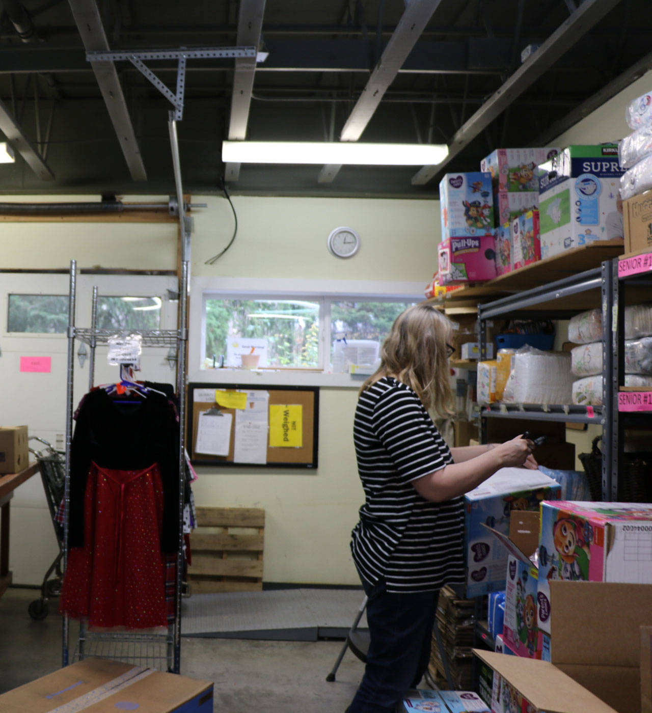 A volunteer for Sharenet takes inventory of food and clothing items.