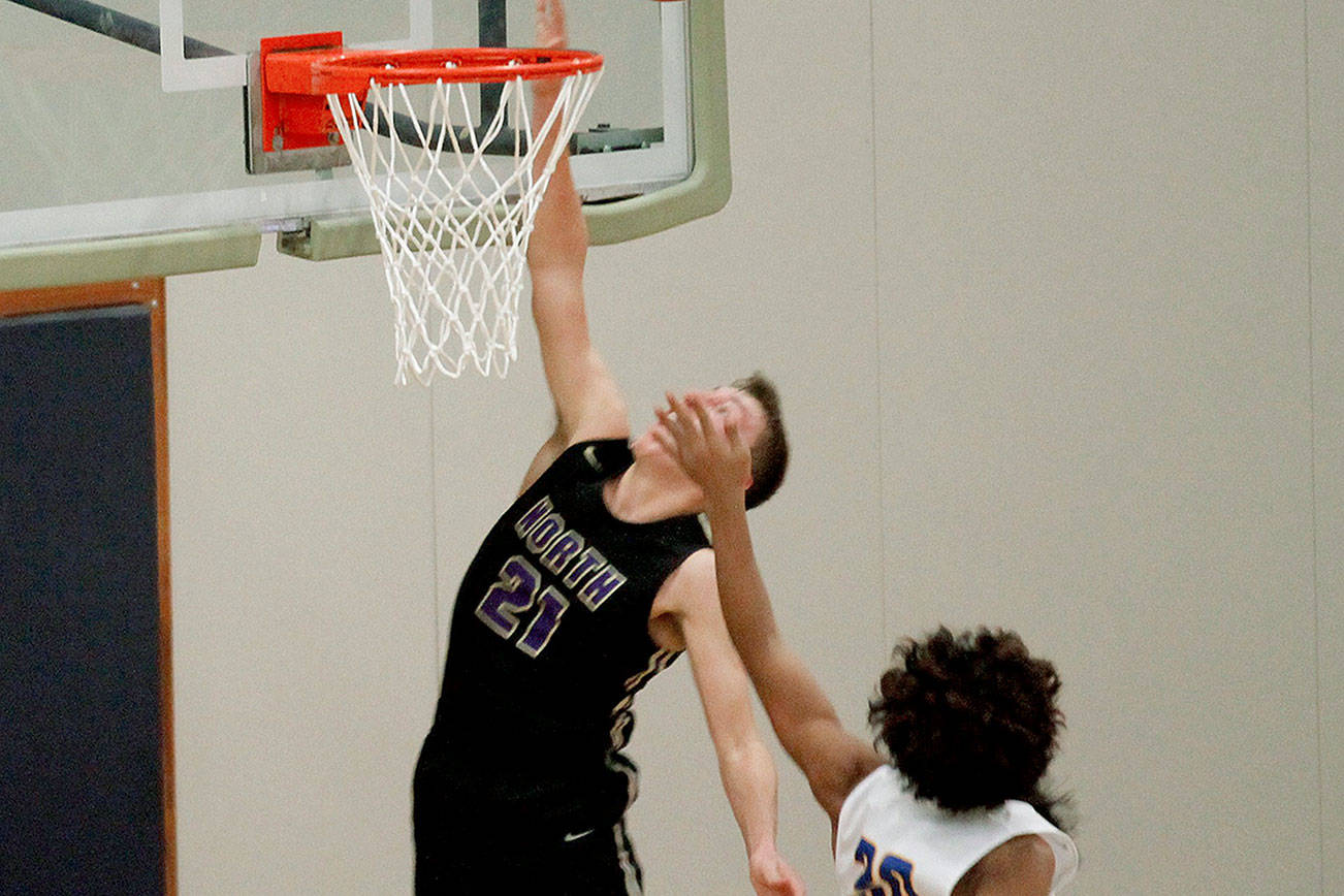 Logan Chmielewski of North Kitsap goes up over Kimo Retome (30) of Bremerton in the Vikings’ 86-52 victory. (Mark Krulish/Kitsap News Group)