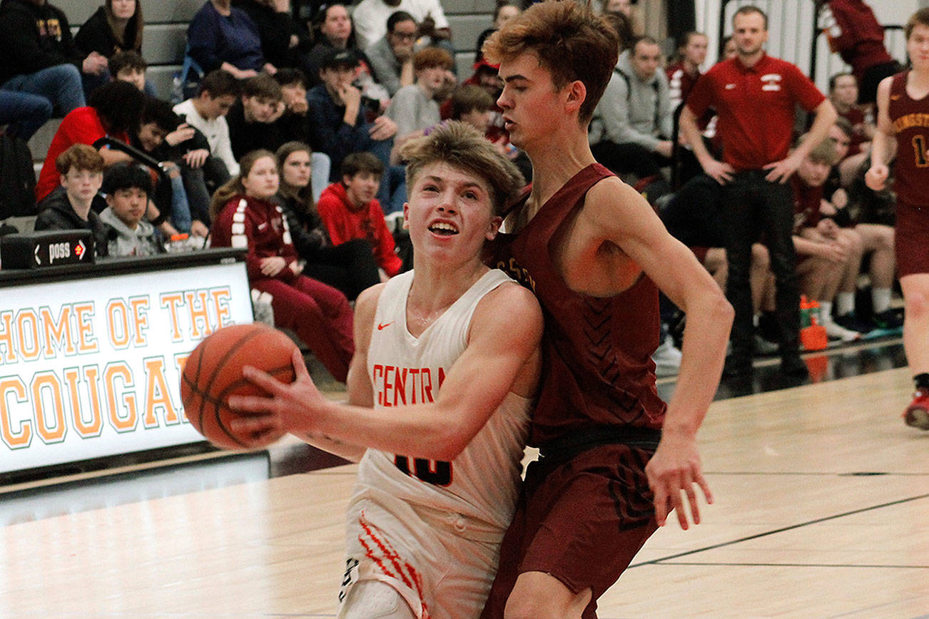 Colby White (10) tries to squeeze past Kingston Trichler in Central Kitsap’s 65-40 win over the Bucs. (Mark Krulish/Kitsap News Group)