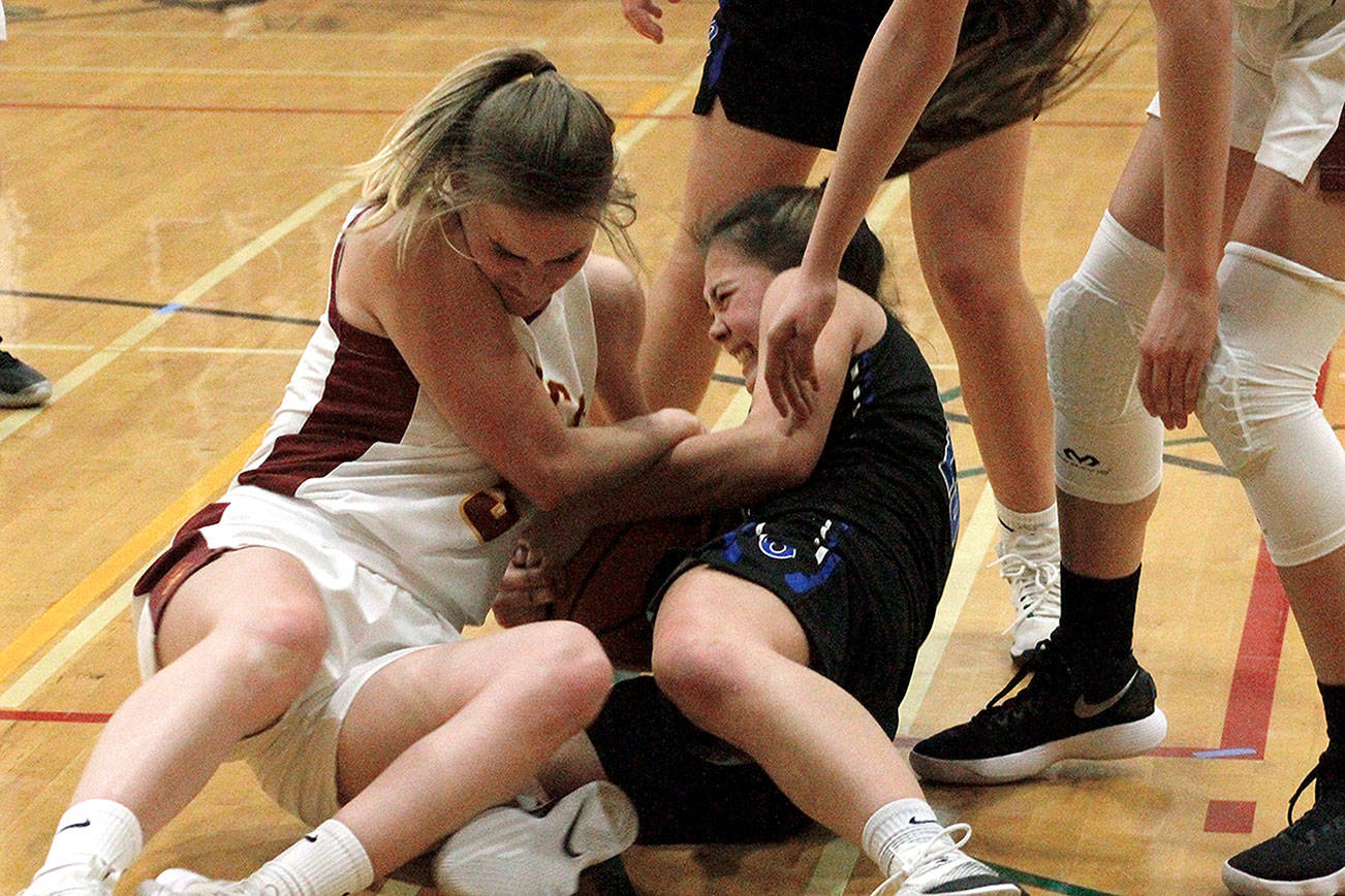 Kingston’s Suzanne Skinner (left) and Olympic’s Midori Carrier wrestle for a loose ball. (Mark Krulish/Kitsap News Group)