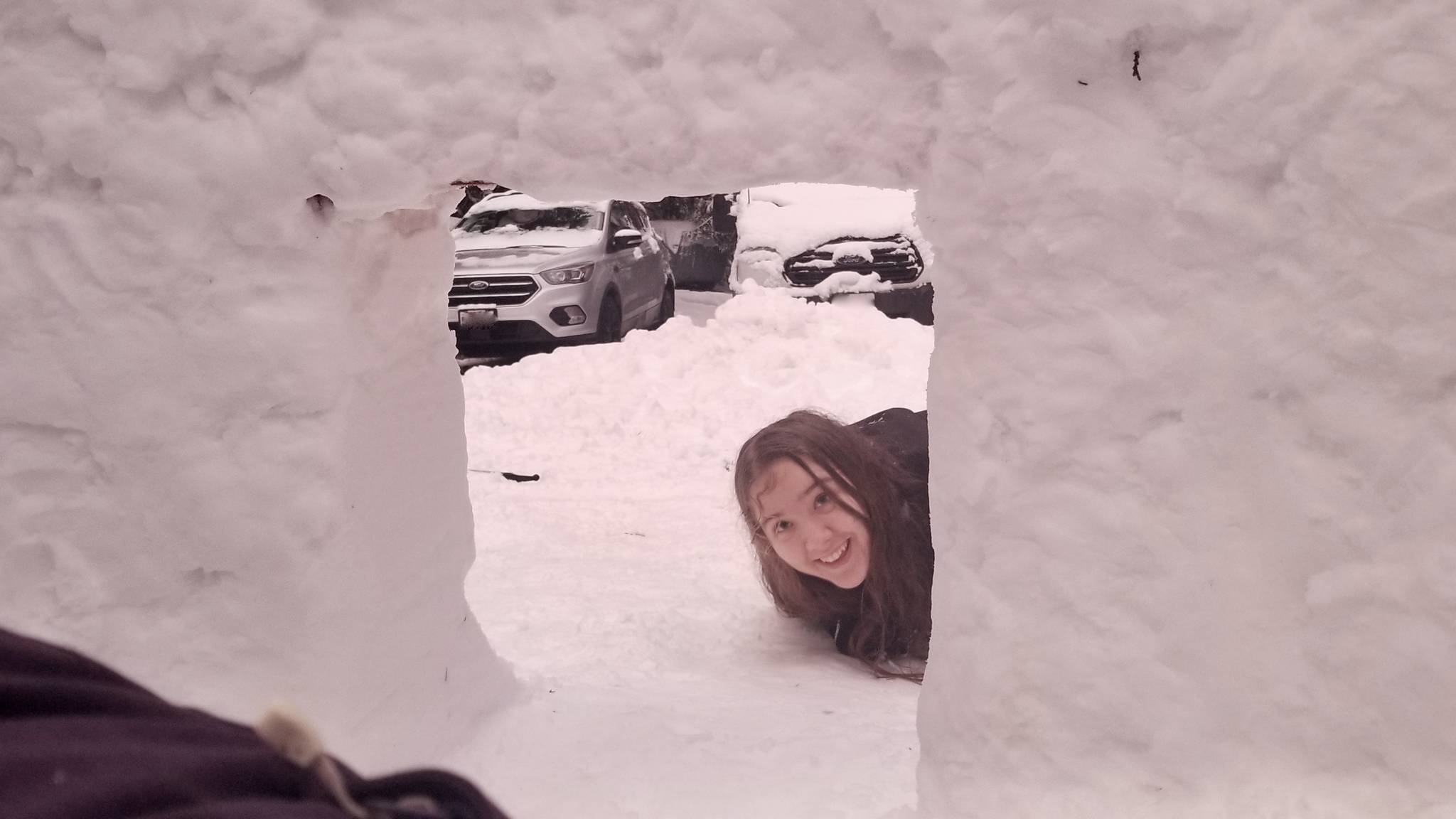 Natalie Peterson, 15, smiles for the camera as she prepares to climb into the igloo (photo by Stella Peterson)