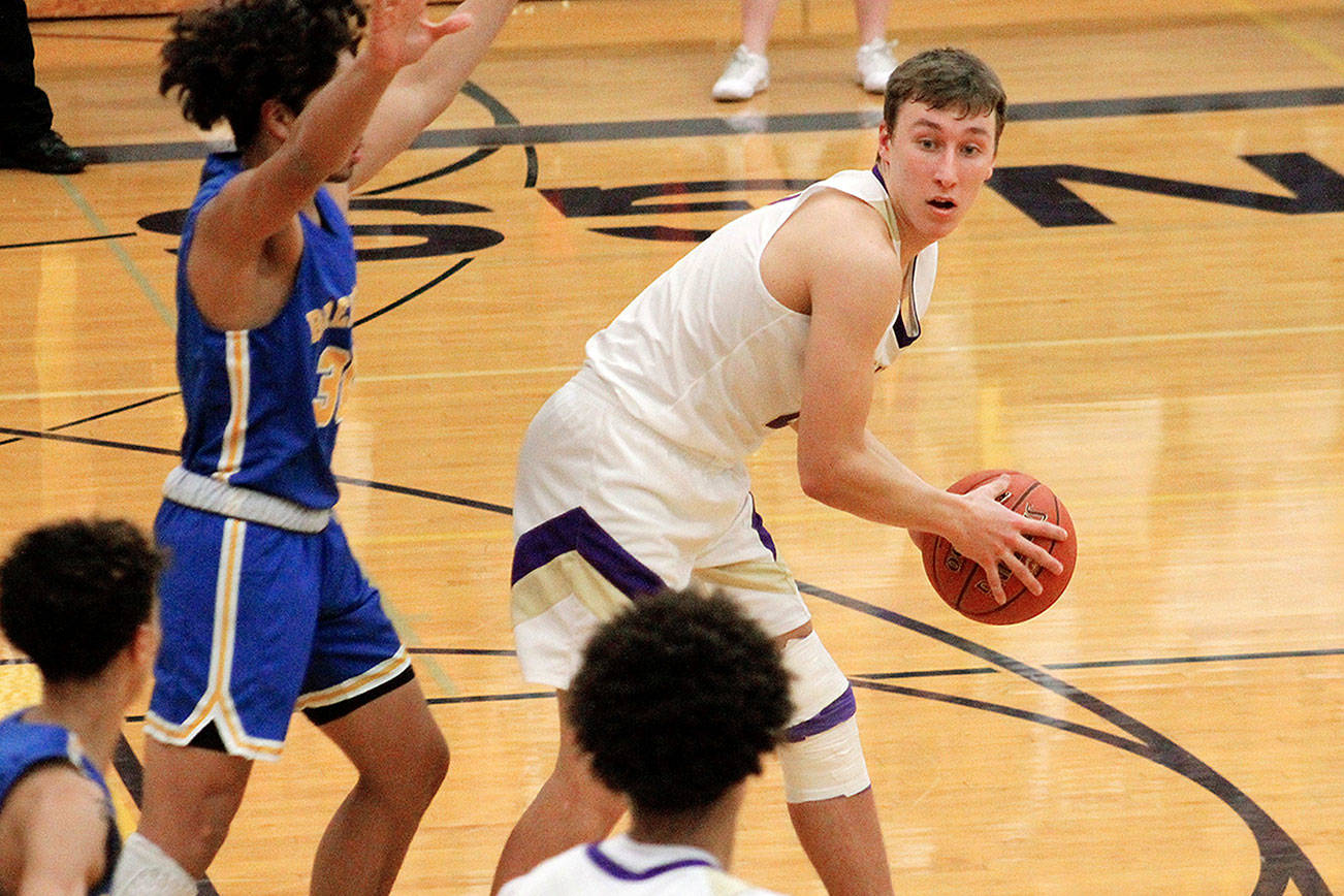 North Kitsap’s Logan Chmielewski looks for an open teammate as he is defending by Bremerton’s Kimo Retome. Chmielewski finished his team’s 84-55 win over the Knights with 12 points. (Mark Krulish/Kitsap News Group)