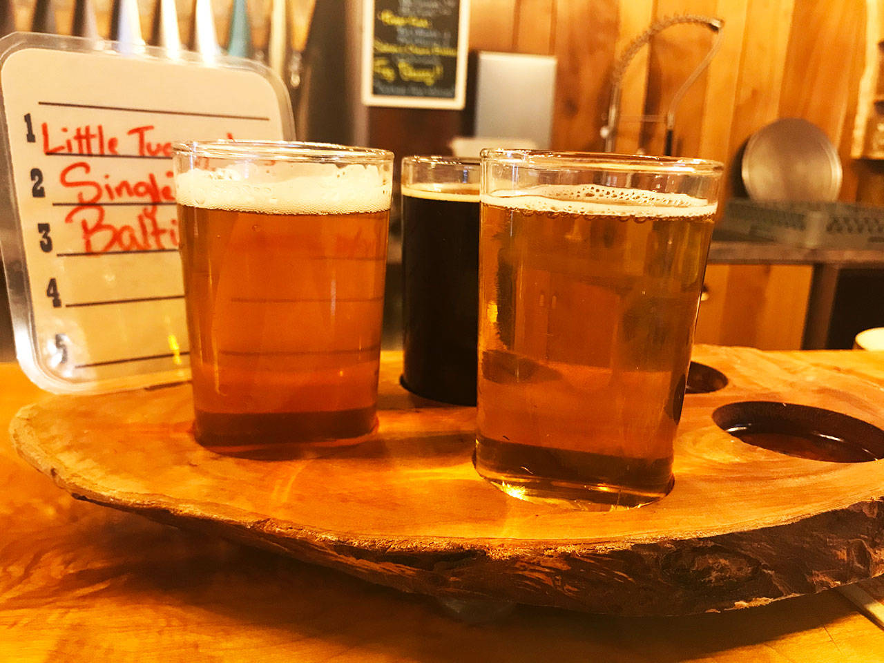 Western Red Brewing serves its tasters up on a slab of wood fitting to its milling aesthetic. (Photo by Ken Park)