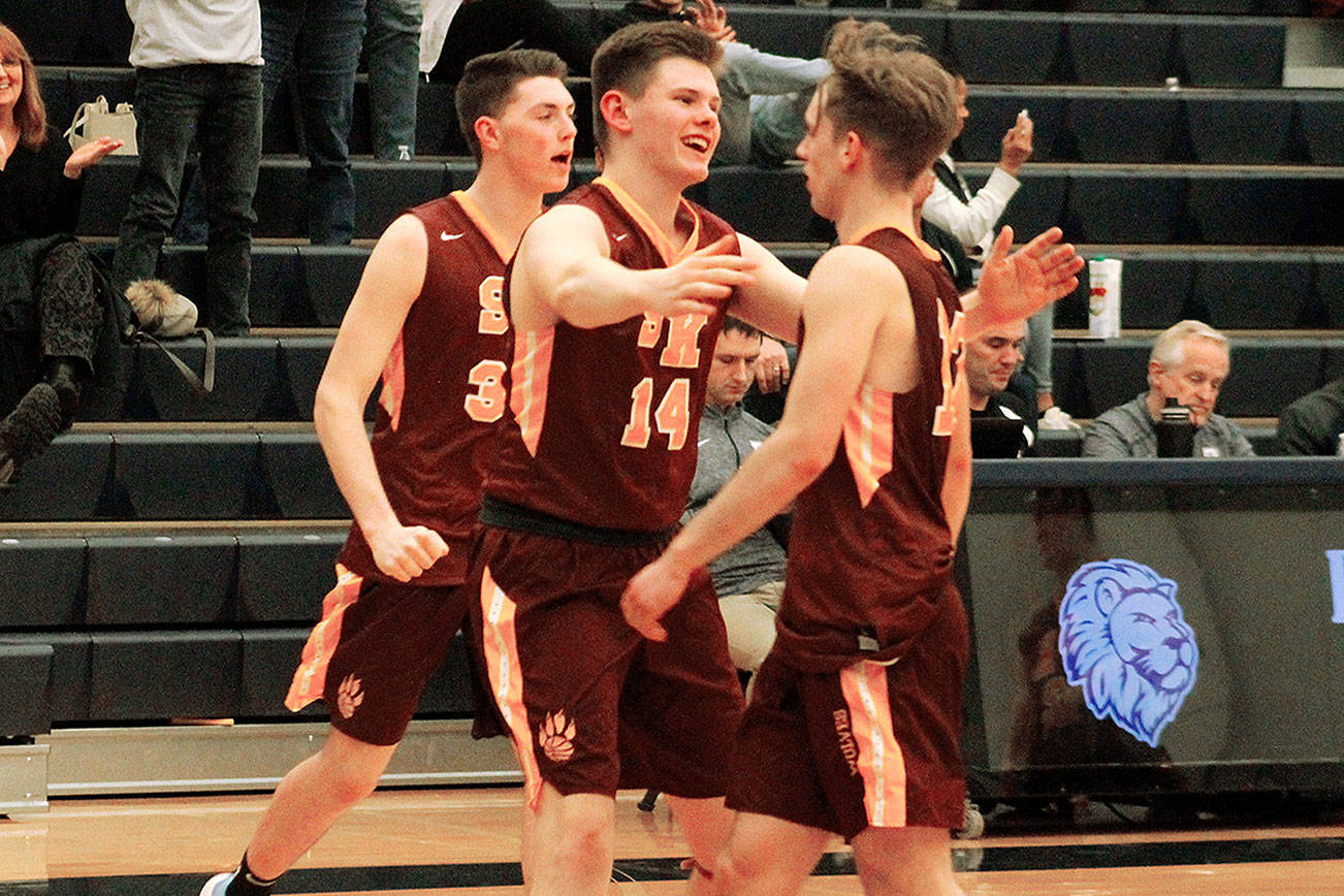 Jack Kees (14) and Kyler Kelso rush out to celebrate with Eli Mackie (12) after time expired in South Kitsap’s 64-61 double-overtime victory over Bellarmine Prep. (Mark Krulish/Kitsap News Group)