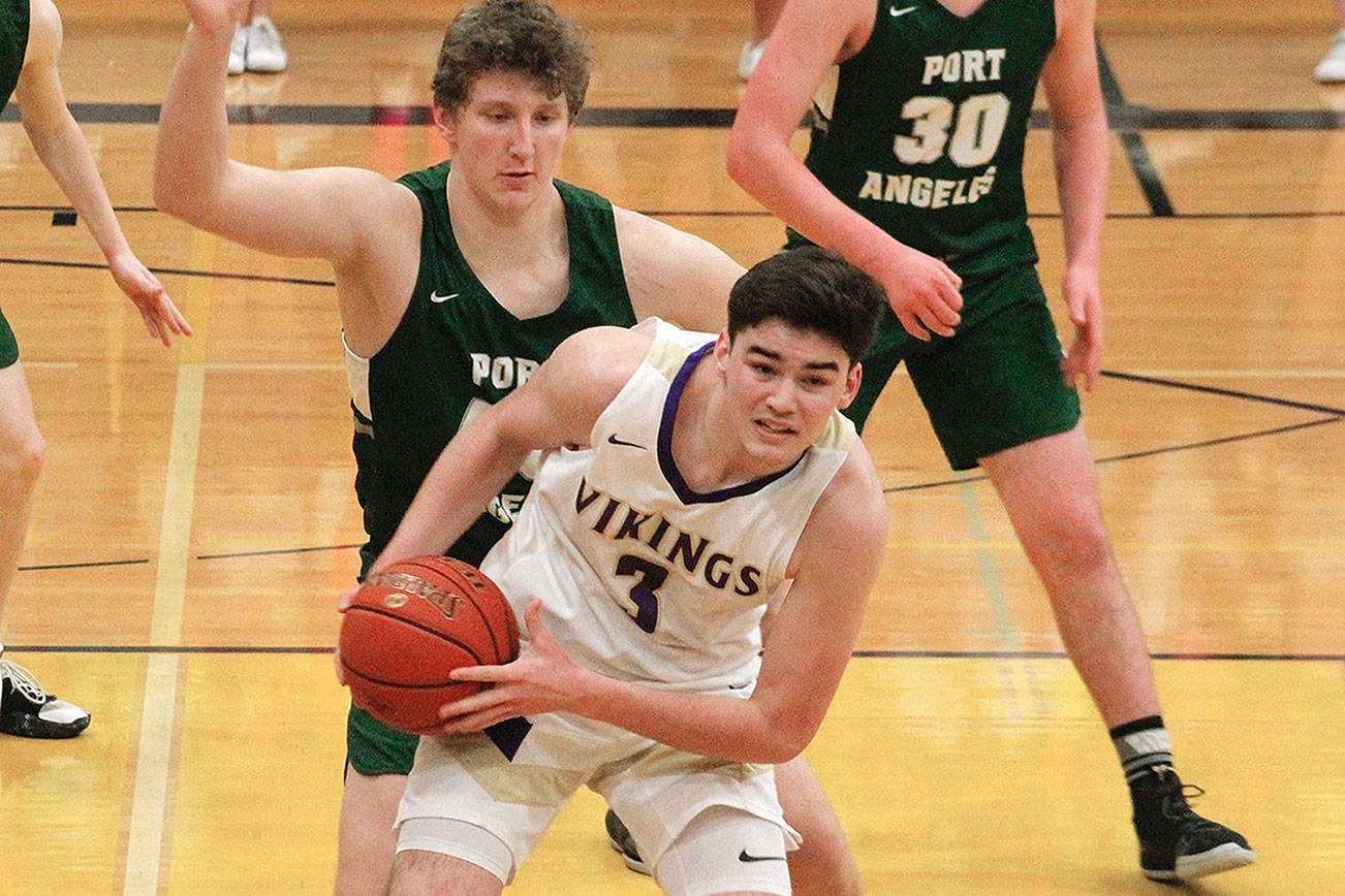 Aiden Olmstead looks for an open teammate while Port Angeles’s John Vaara applies the pressure. (Mark Krulish/Kitsap News Group)