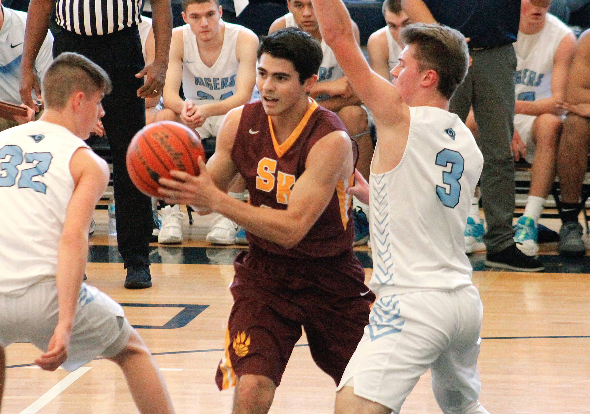South Kitsap’s Jonathan Walters looked for a way to the hoop while sandwiched by two Rogers defenders in their tiebreaker game Saturday. (Mark Krulish/Kitsap News Group)