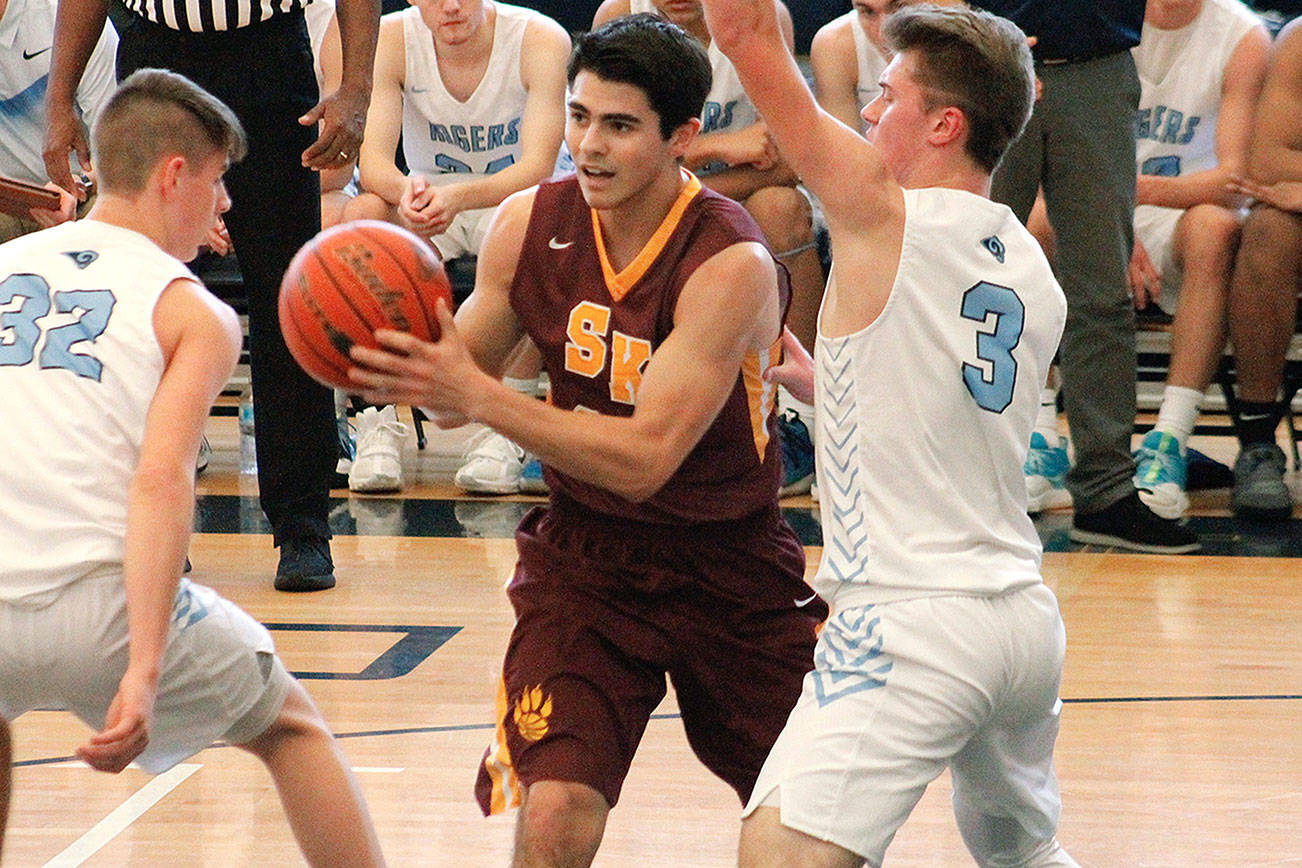 South Kitsap’s Jonathan Walters looked for a way to the hoop while sandwiched by two Rogers defenders in their tiebreaker game Saturday. (Mark Krulish/Kitsap News Group)