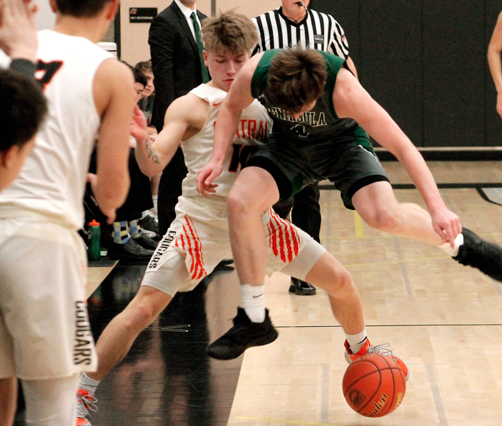 Peninsula’s Cole McVay and Central Kitsap’s Colby White battle for a loose ball in the first quarter of their district playoff game. (Mark Krulish/Kitsap News Group)