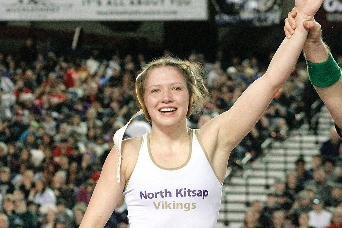 Holly Beaudoin with her arm raised by the referee after she became a state champion at the Mat Classic. (Mark Krulish/Kitsap News Group)