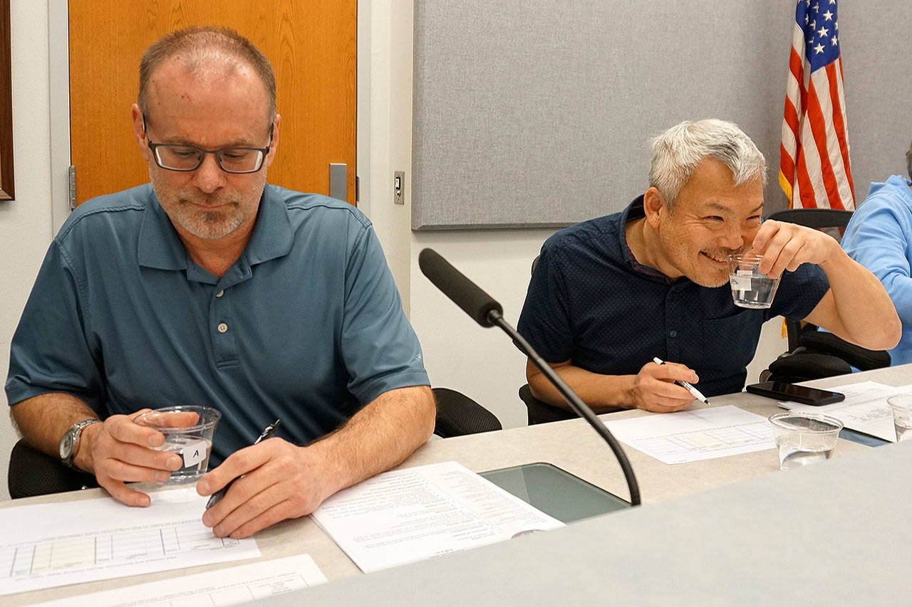 Port Orchard City Council members Scott Diener (left) and Fred Chang evaluate water samples in a blind taste test. (Bob Smith | Kitsap Daily News)