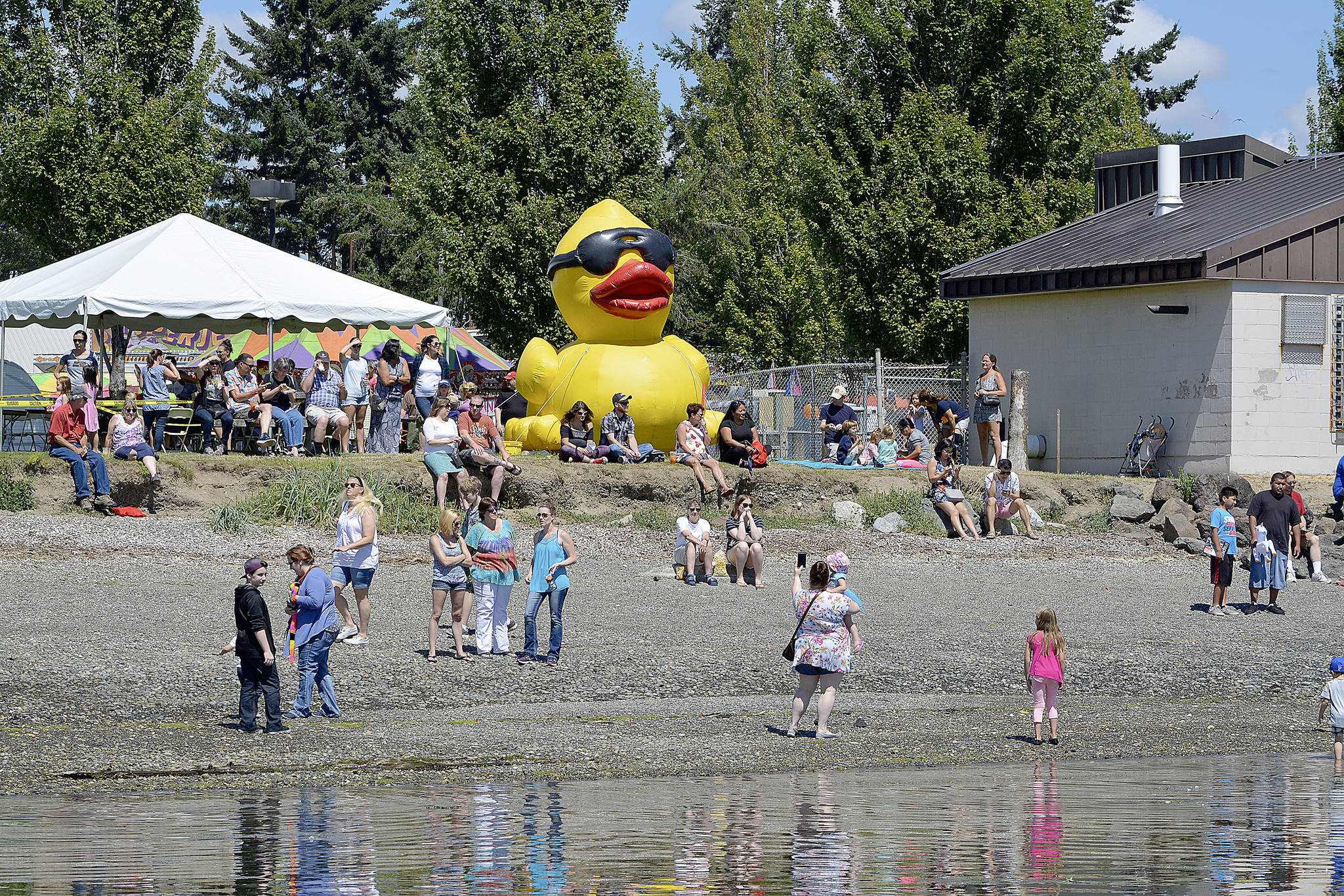 A crowd gathers on the beach at Silverdale Waterfront Park to watch the Rotary Club Duck Race. This type of gathering still may not be allowed for some time. (Mark Krulish/Kitsap News Group)