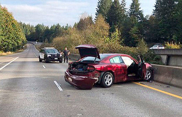 The suspects’ maroon Dodge Charger is damaged on Highway 16 at the Tremont Street interchange after crashing while heading in the wrong direction Friday morning. The men fled the crash and headed into a wooded, swampy area to elude law enforcement. One of the suspects was later captured.