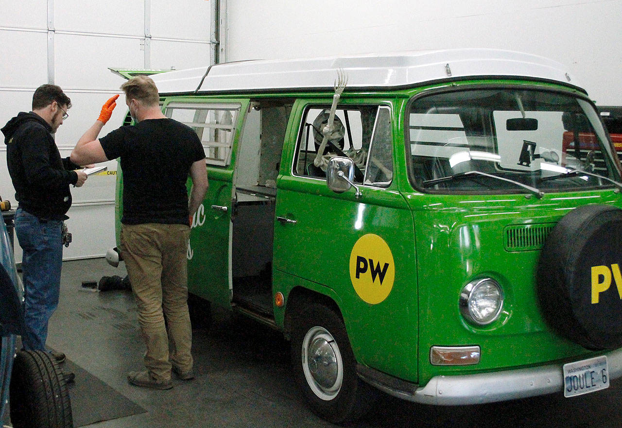 EV Works technicians take a look at Joule, the shop's electric Volkswagen bus. (Mark Krulish/Kitsap News Group)