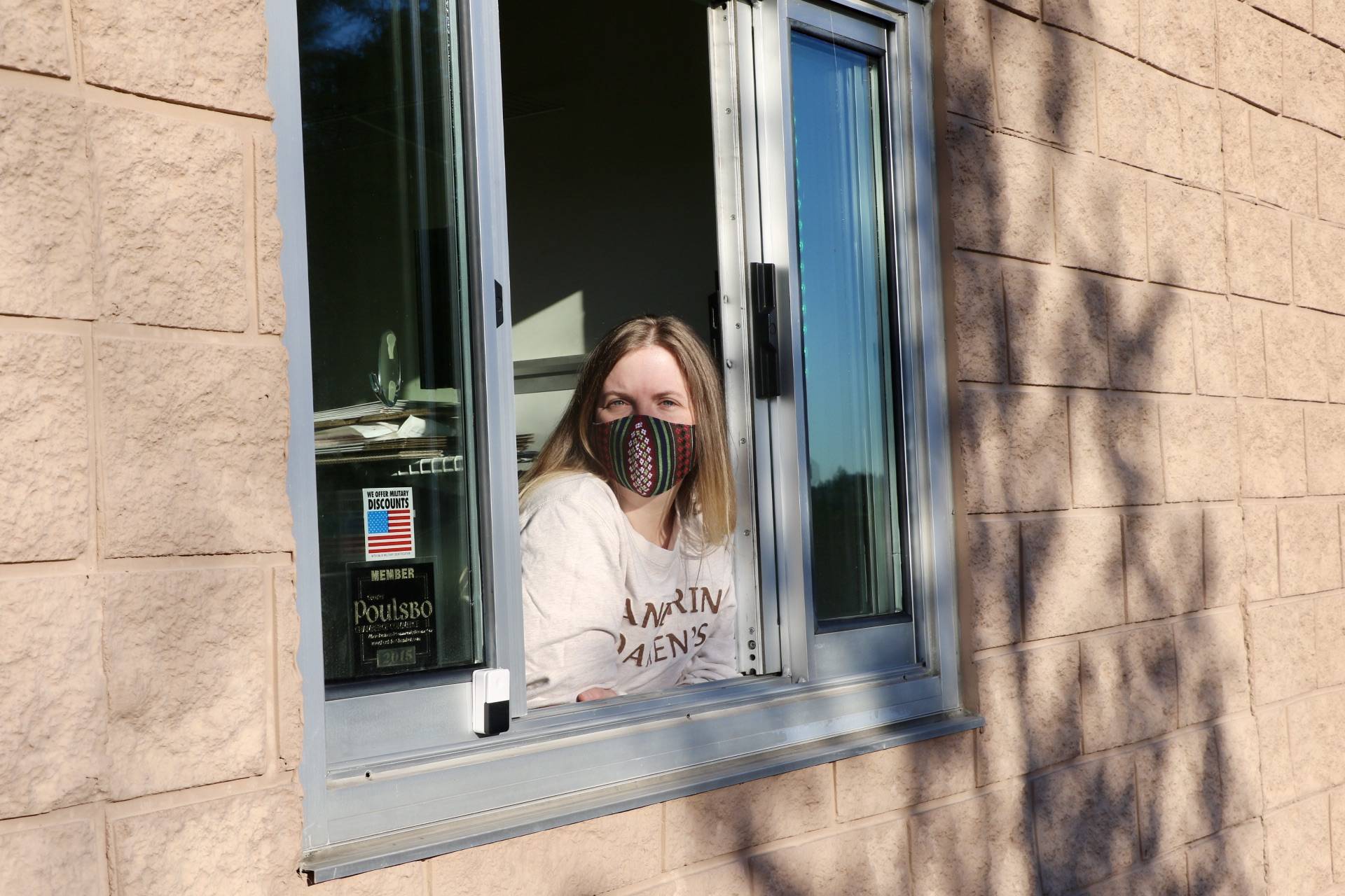 <em>Jenna DeTrapani, owner of Poulsbo’s newest shop, BookIt Nook, hangs out of the drive-thru window, ready for the next customer. </em>							 Ken Park/North Kitsap Herald photographs