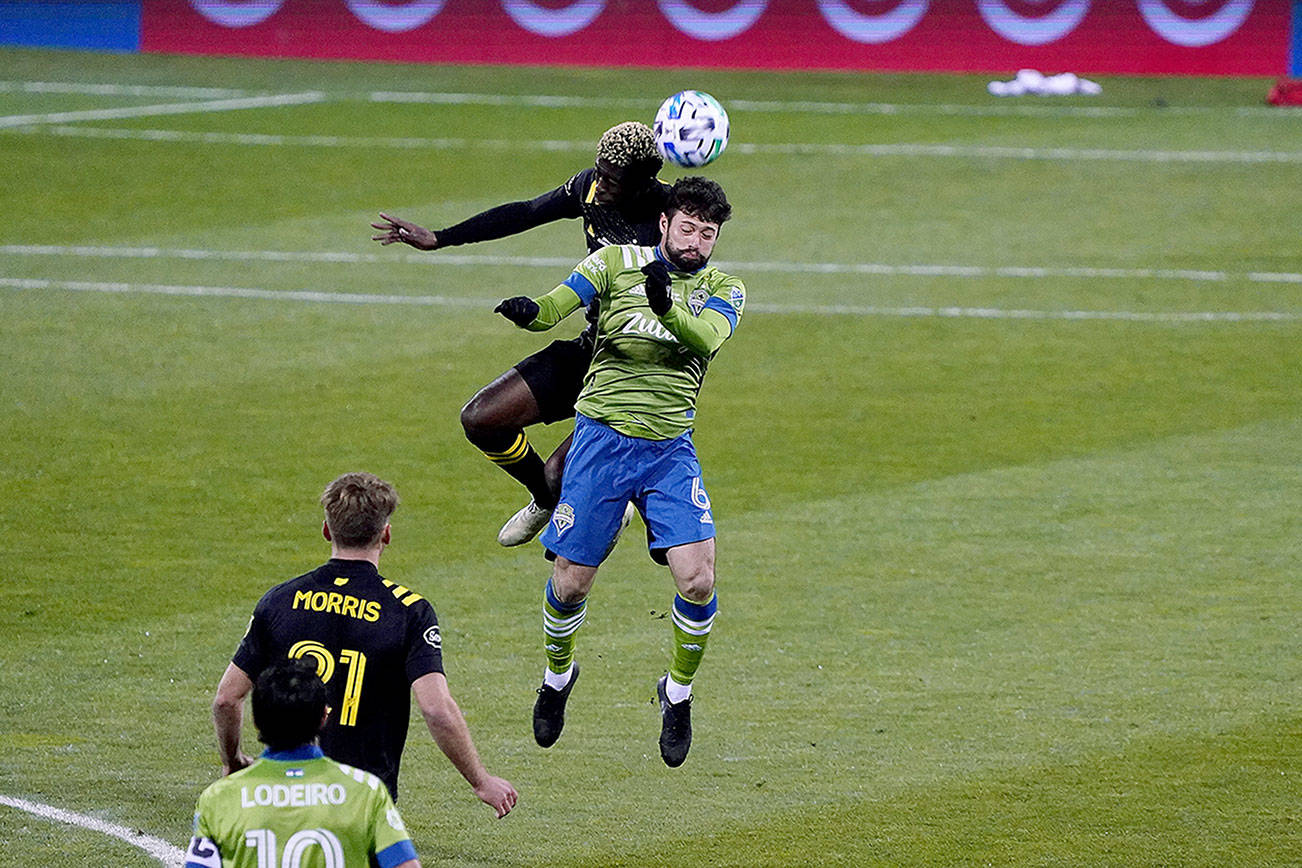 Sounders midfielder João Paulo tries to out-leap a Columbus player for the ball in the MLS Cup. (Mike Fiechtner/Sounders FC Communications)