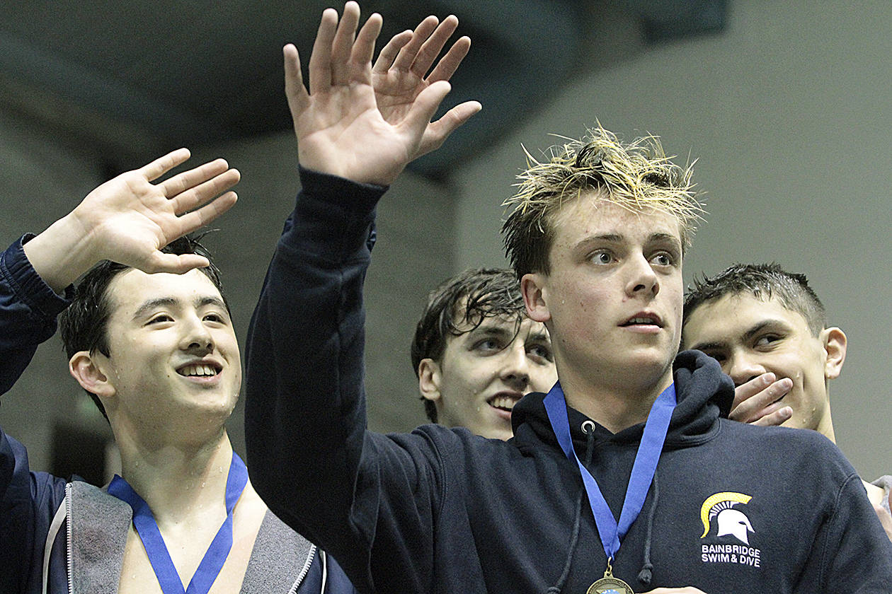 The Spartan state championship 200-yard freestyle relay team waves to the crowd from the winners platform. From left, Jude Wenker, Andrew Witty, Harrison Villella, and Tyler Stewart. (Review file photo)