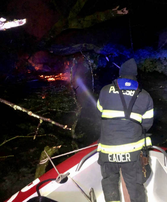 A Poulsbo firefighter extinguishes the flames of a structure fire caused by a landslide in LoFall. Courtesy photo